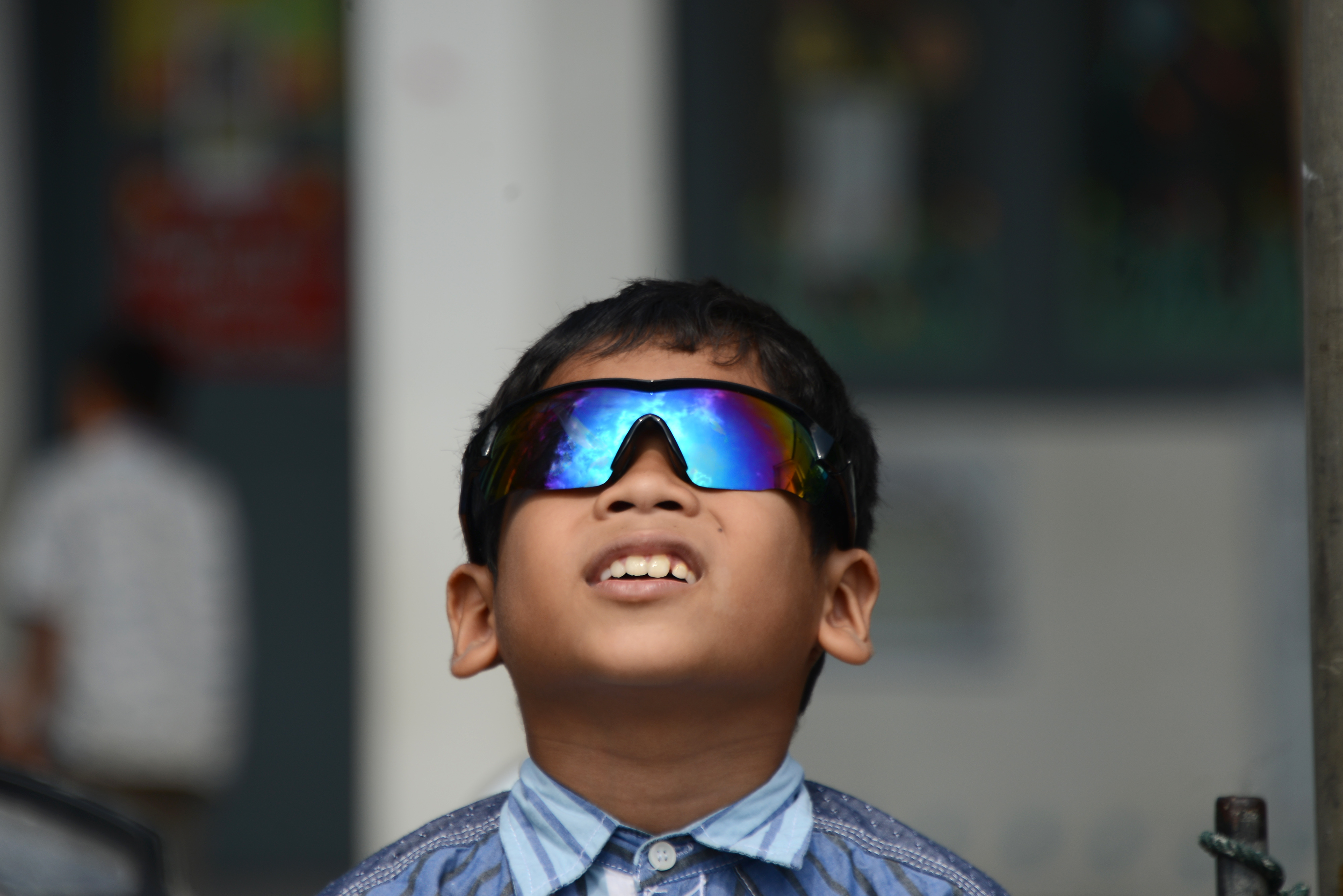 Seorang anak menyaksikan fenomena gerhana matahari cincin menggunakan kacamata di Desa Punge Blang Cut, Banda Aceh, Aceh, Kamis (26/12/2019)