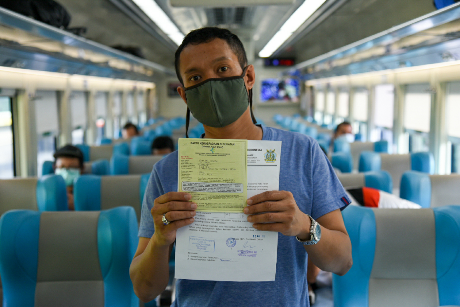Penumpang kereta api jarak jauh menunjukkan surat negatif cpvid-19 dan sertifikat vaksin sebagai syarat perjalanan moda darat.