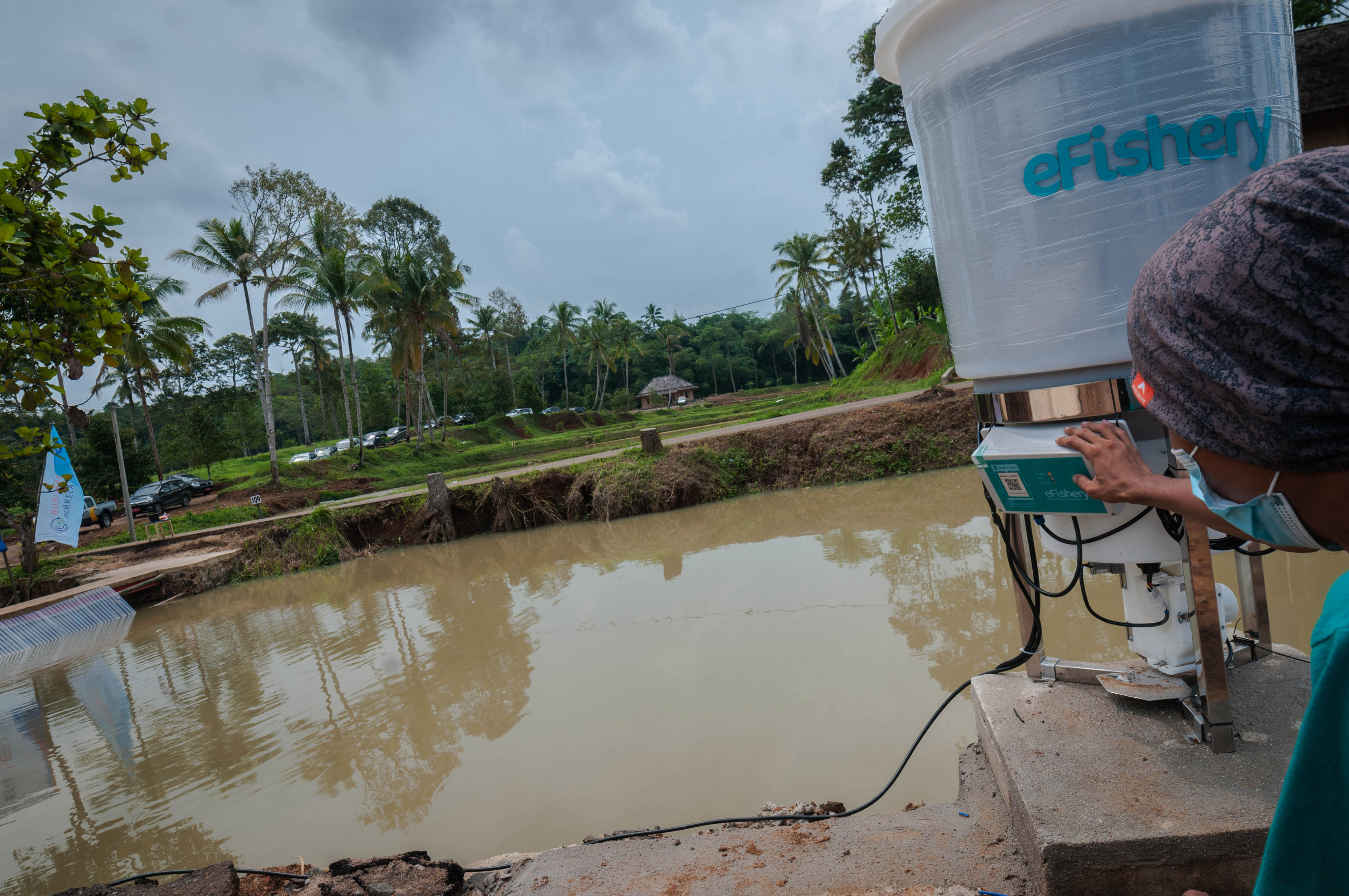  Pekerja mengaktifkan perangkat e-Fishery SmartFeeder atau pemberi pakan pintar di Cileles, Lebak, Banten. 