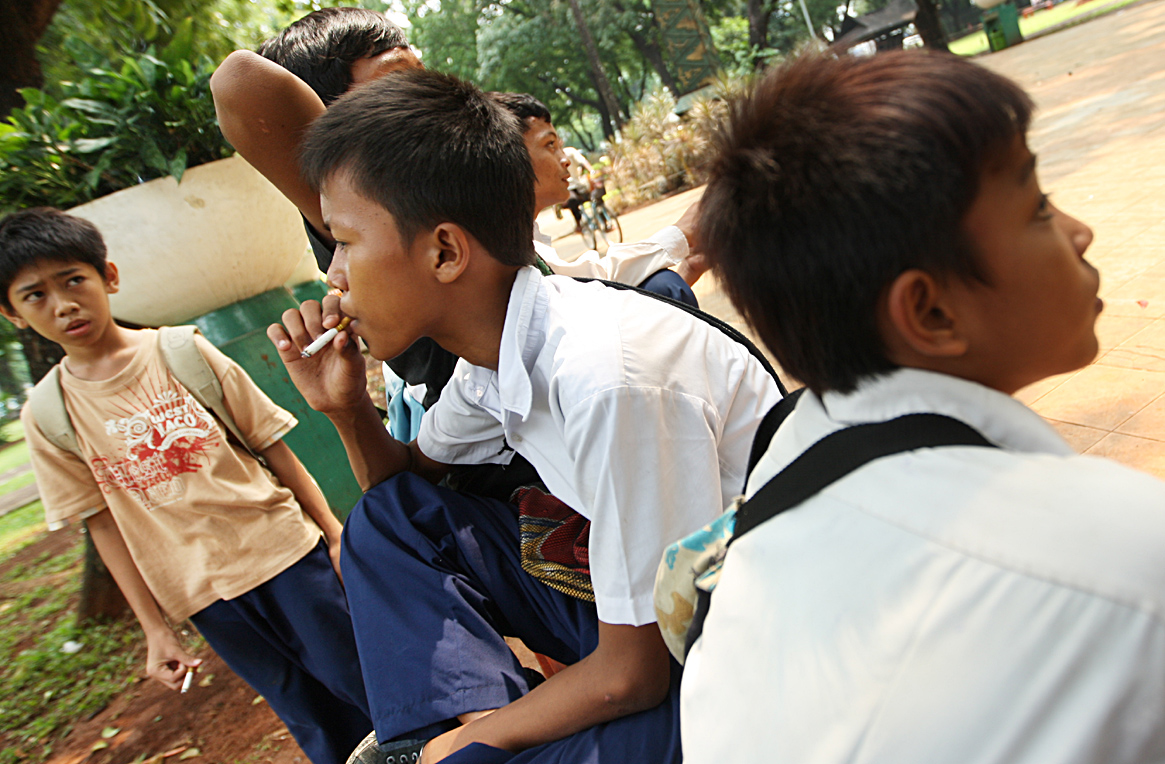 Sejumlah pelajar SMP sedang merokok di sebuah taman di Jakarta.
