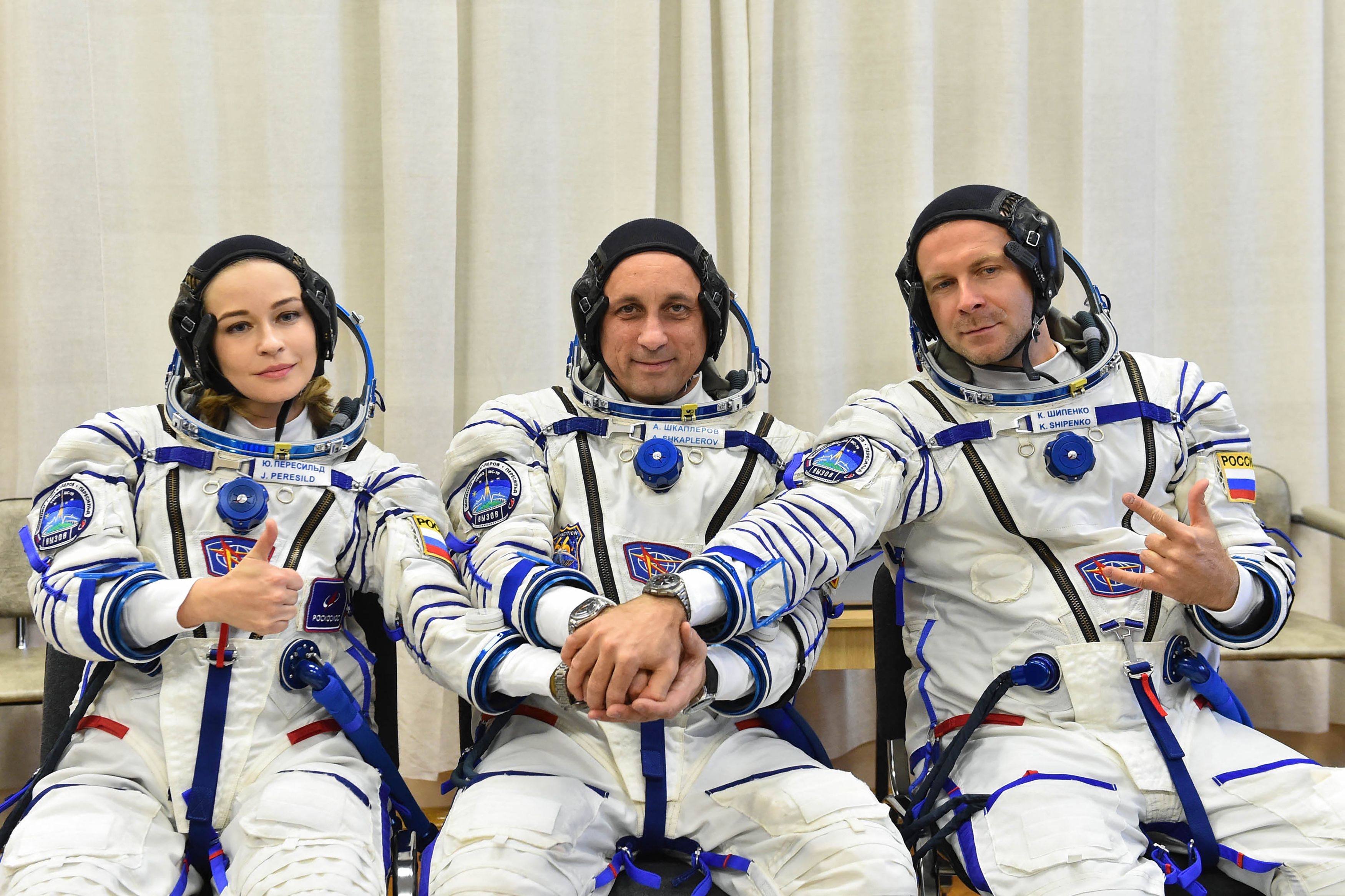 Kru film Rusia Yulia Persild dan Klim Shipenko mengapit kosmonaut Anton Shkaplerov sebelum bertolak ke ISS.