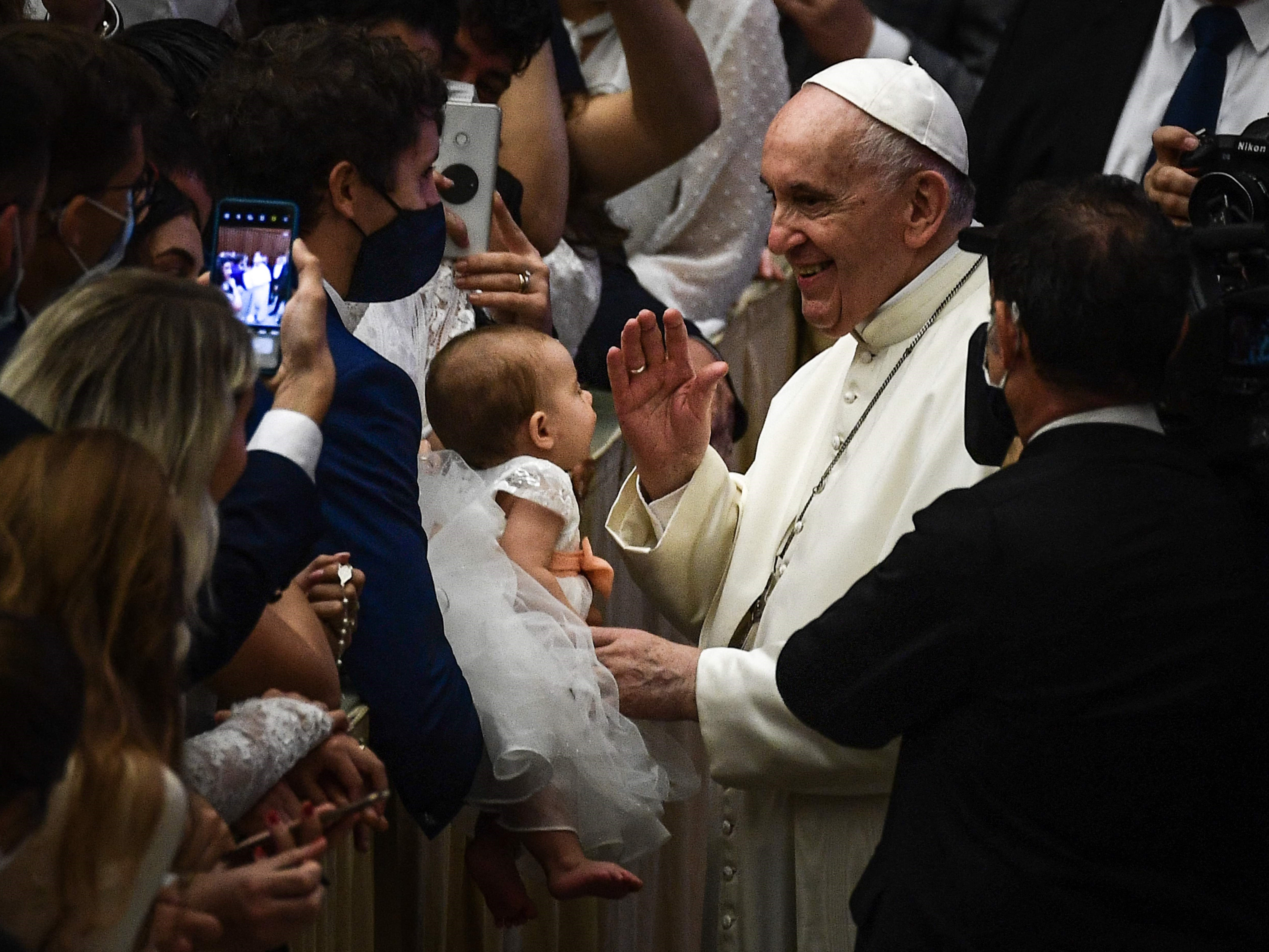 Paus Fransiskus memberkati para hadirin dan seorang bayi selama audiensi umum mingguan, Rabu (6/10), di aula Paulus-VI di Vatikan.