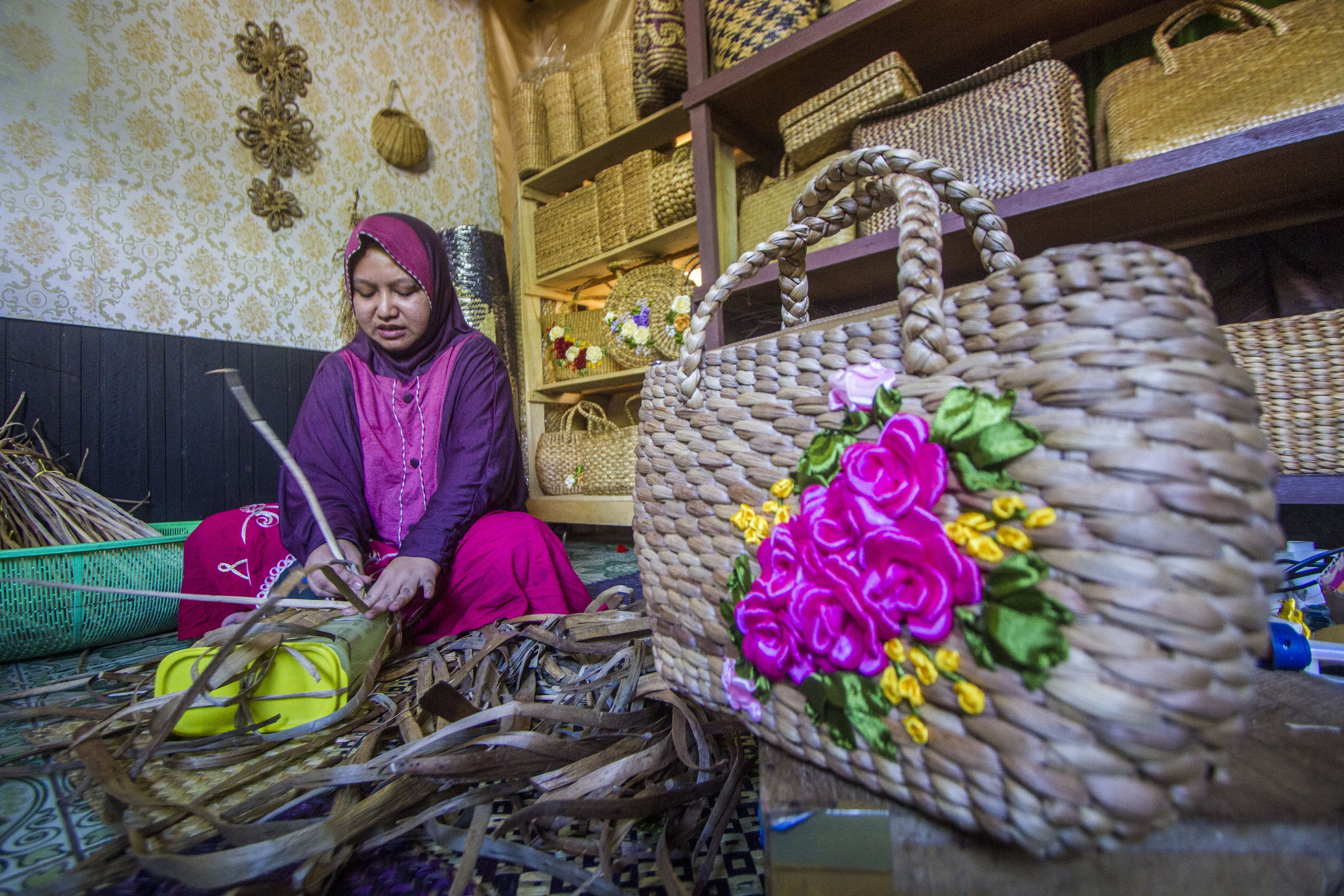 Perajin menyelesaikan kerajinan tas berbahan baku eceng gondok di Mujisela Craft, Hulu Sungai Tengah, Kalimantan Selatan, Sabtu (11/9).