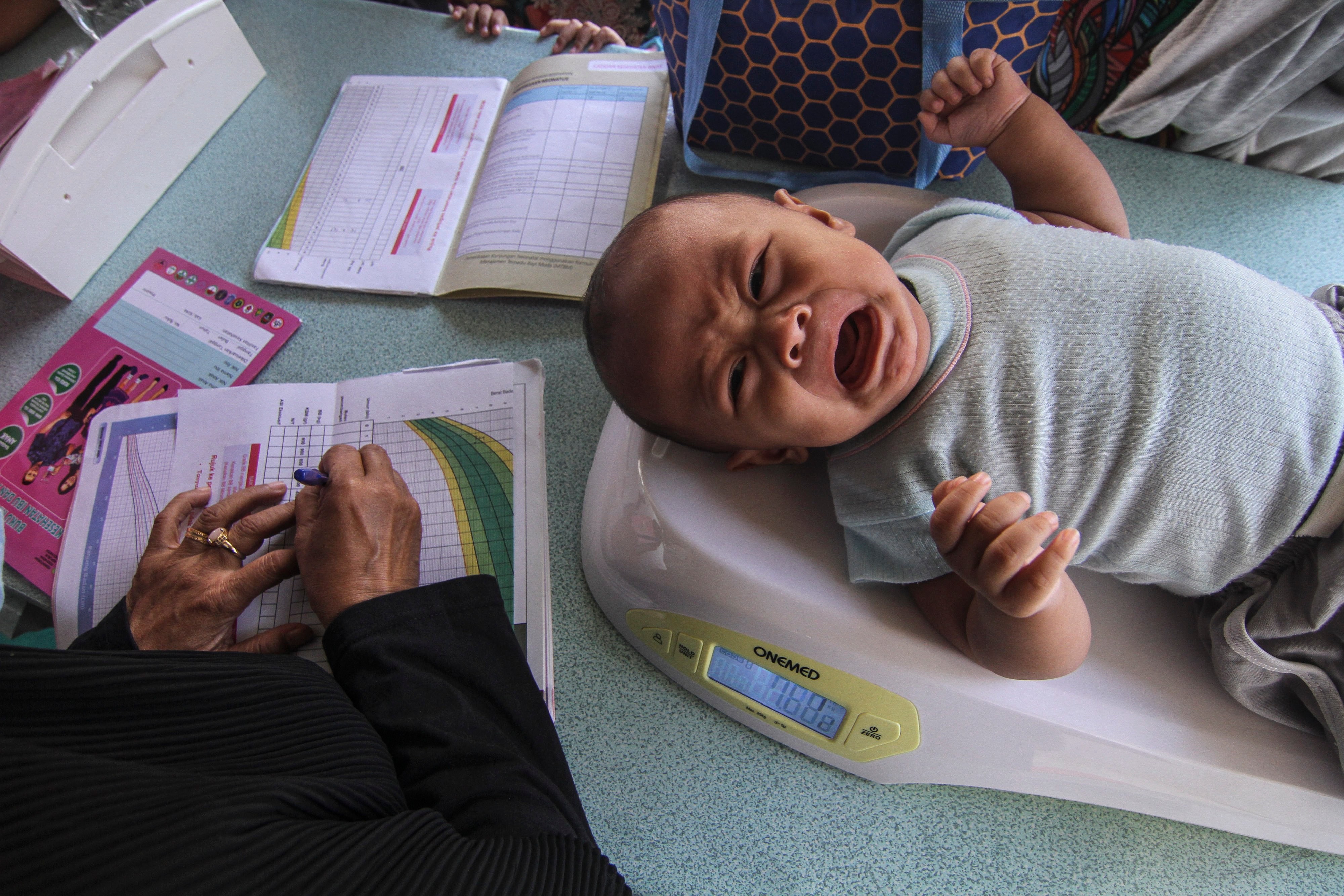  Kader PKK mengukur berat badan balita di Posyandu Angger 2, Cimanggis, Depok, Jawa Barat, Senin (25/10/2021).