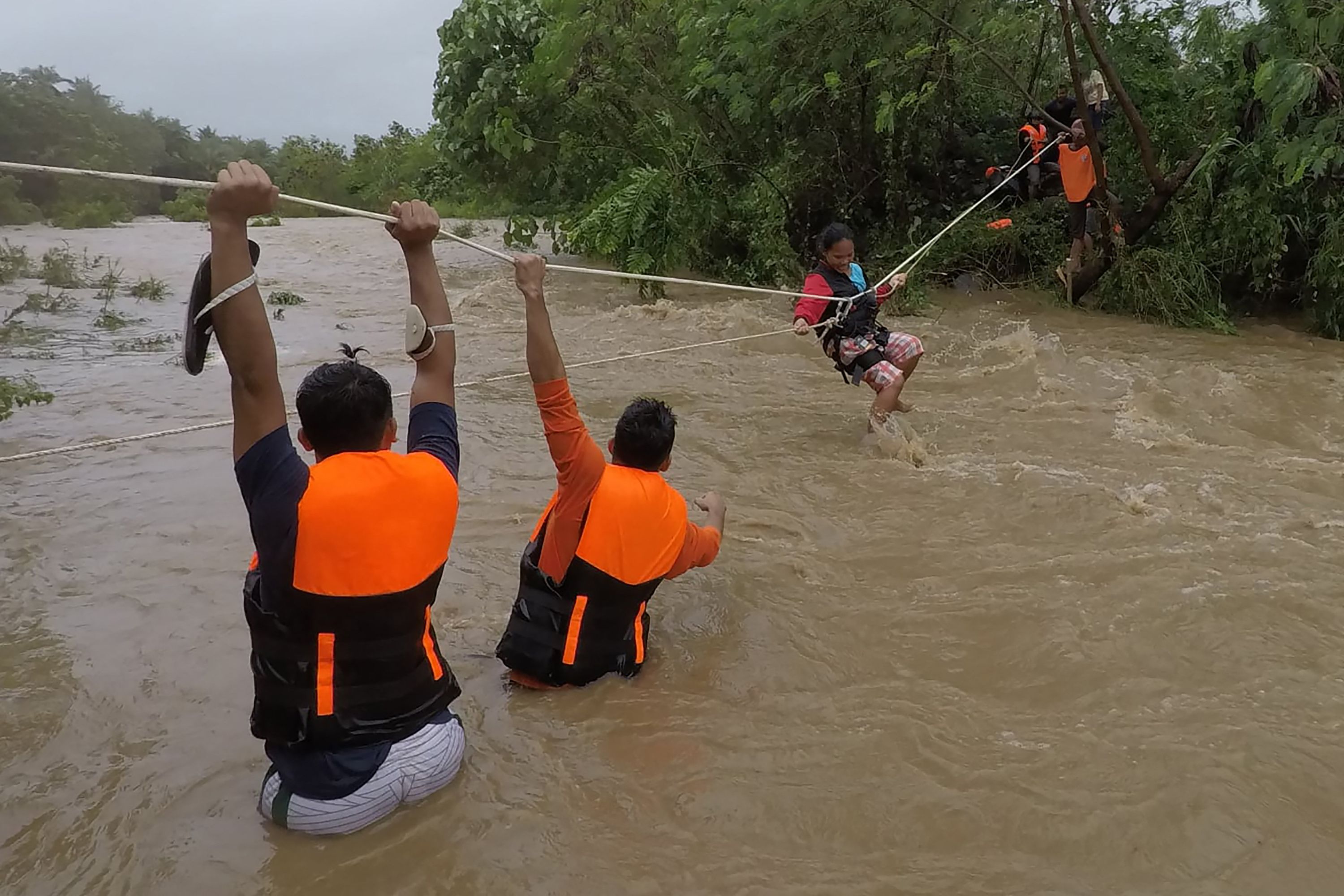 Tim Penanggulang Bencana berusaha menyelamatkan warga yang rumahnya dekat sungai di Kota Gonzaga, Filipina, Senin (11/10).