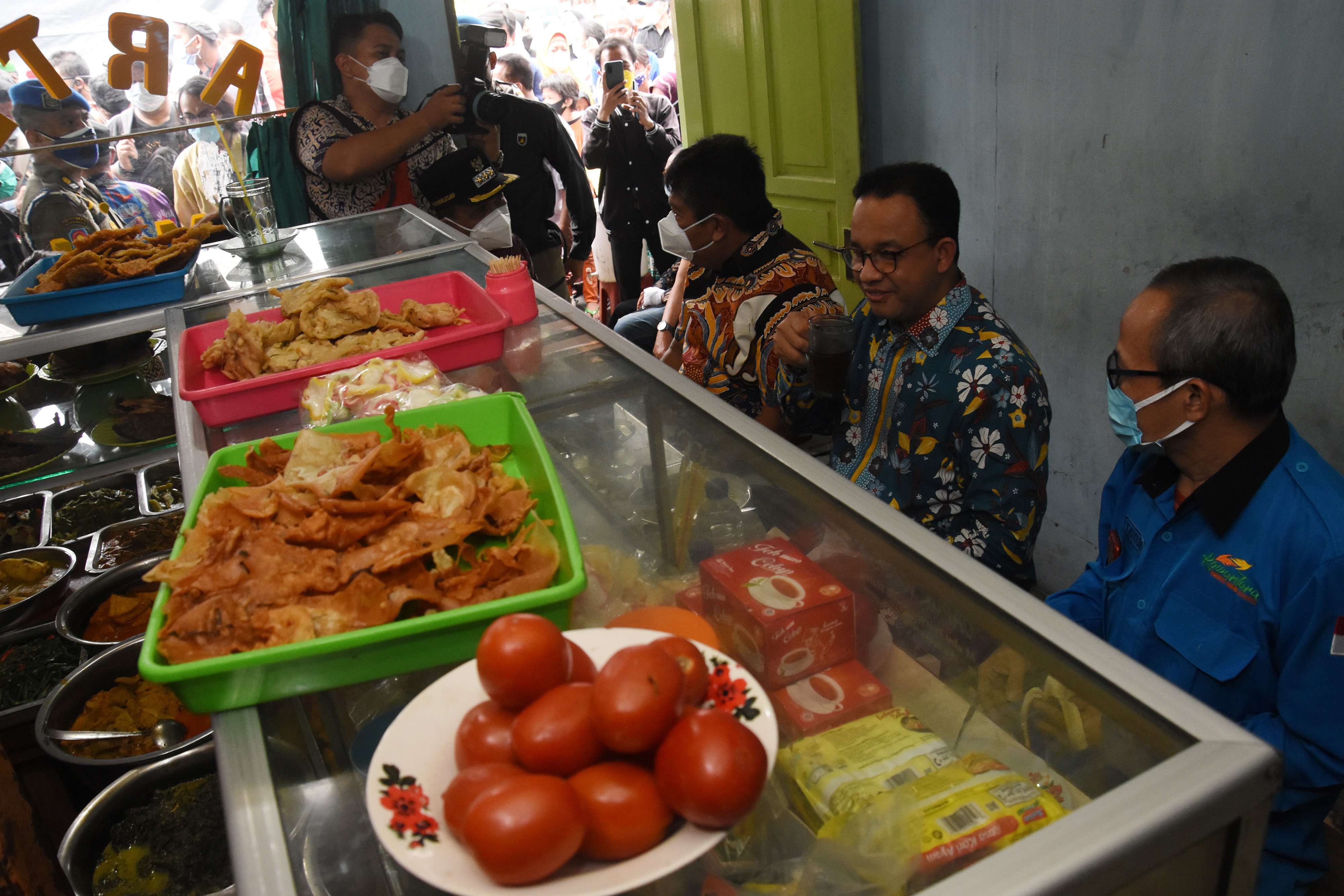 Gubernur DKI Jakarta Anies Baswedan saat menikmati makan siang di salah satu warteg.