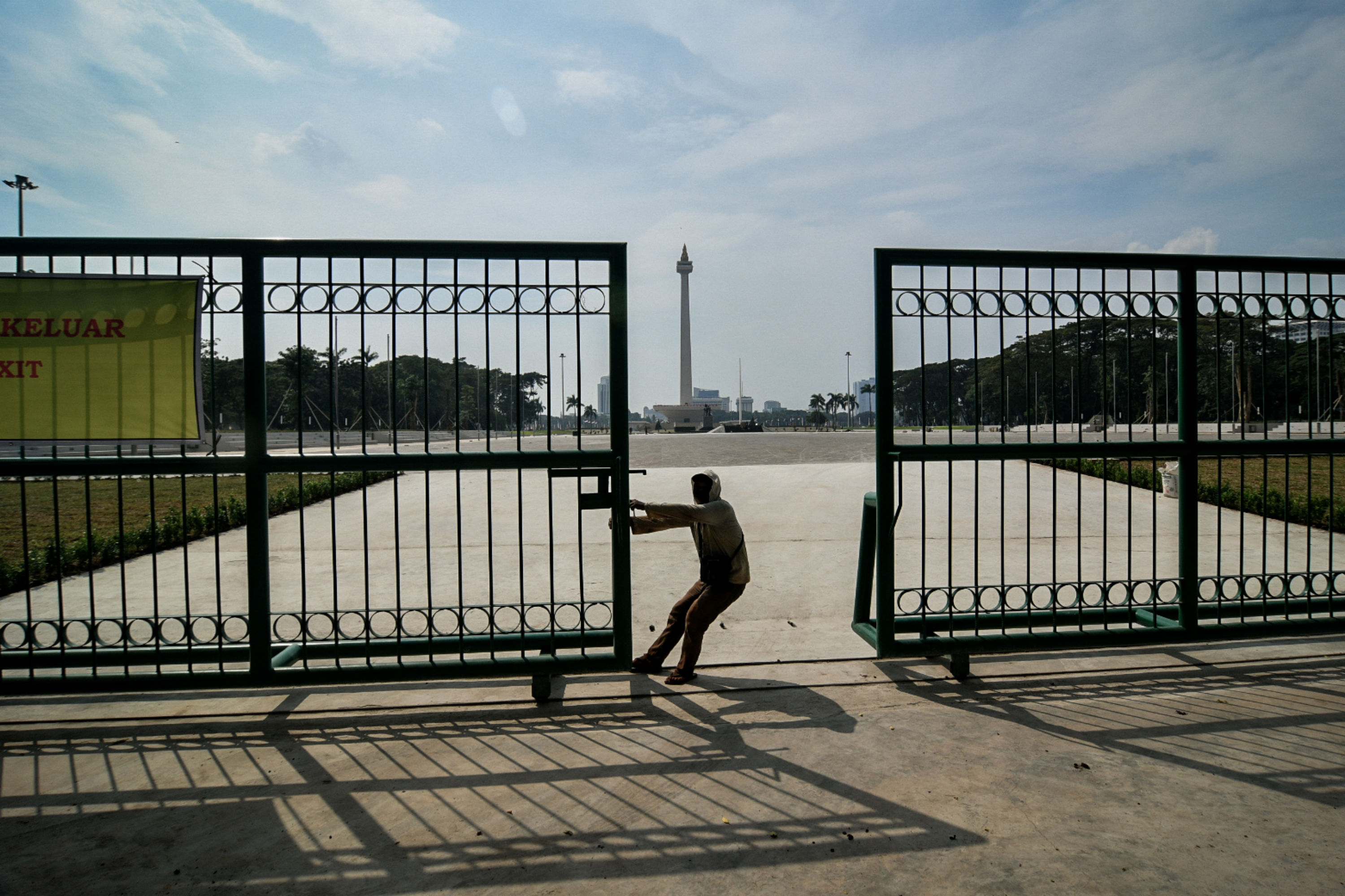 Ilustrasi petugas saat menutup pintu gerbang kawasan Monas, Jakarta.