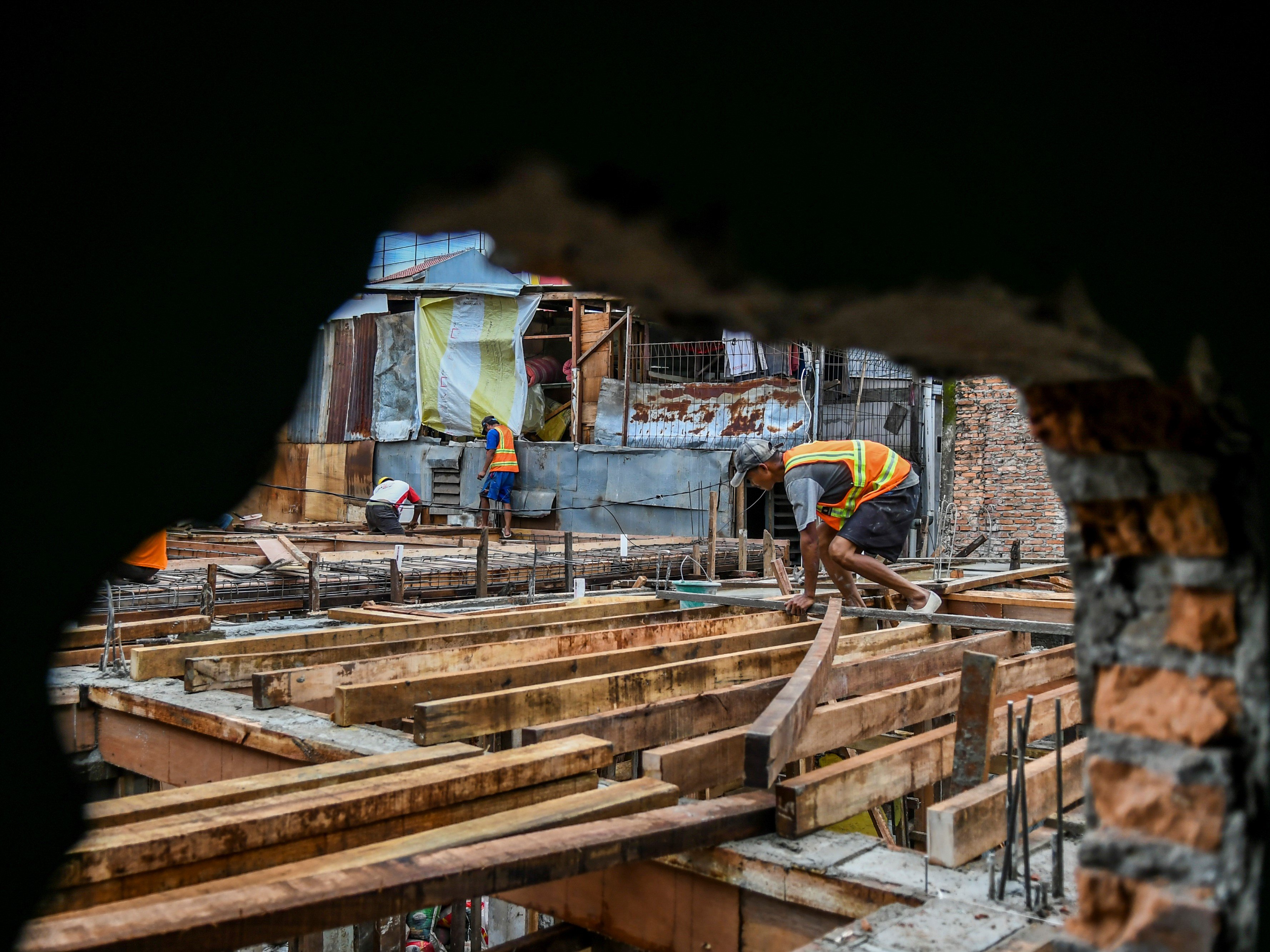 Pekerja menyelesaikan pembangunan rumah panggung di kawasan Kebon Pala, Jakarta, Rabu (7/4/2021).
