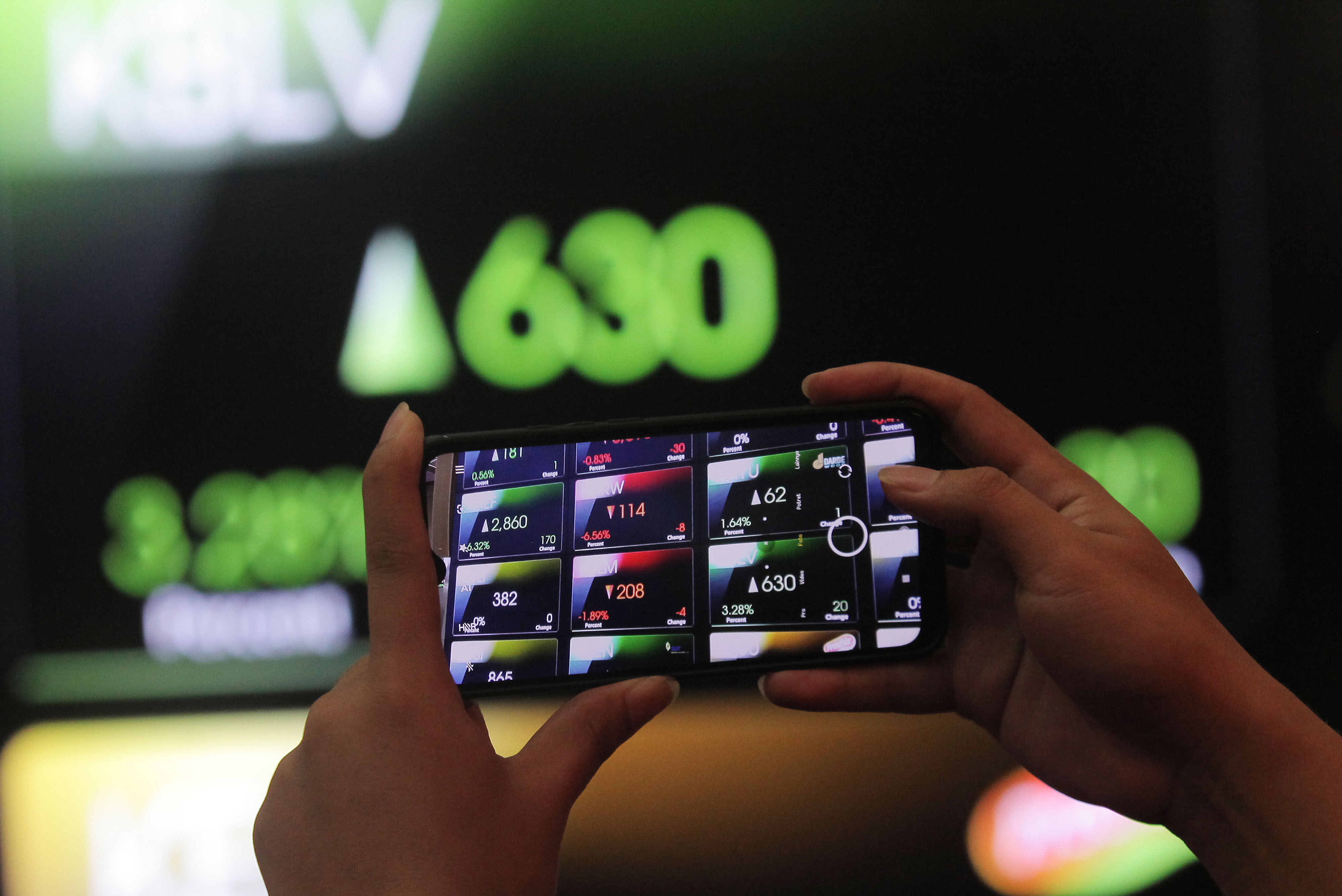 Karyawan memotret layar monitor pergerakan IHSG di gedung BEI, Jakarta.