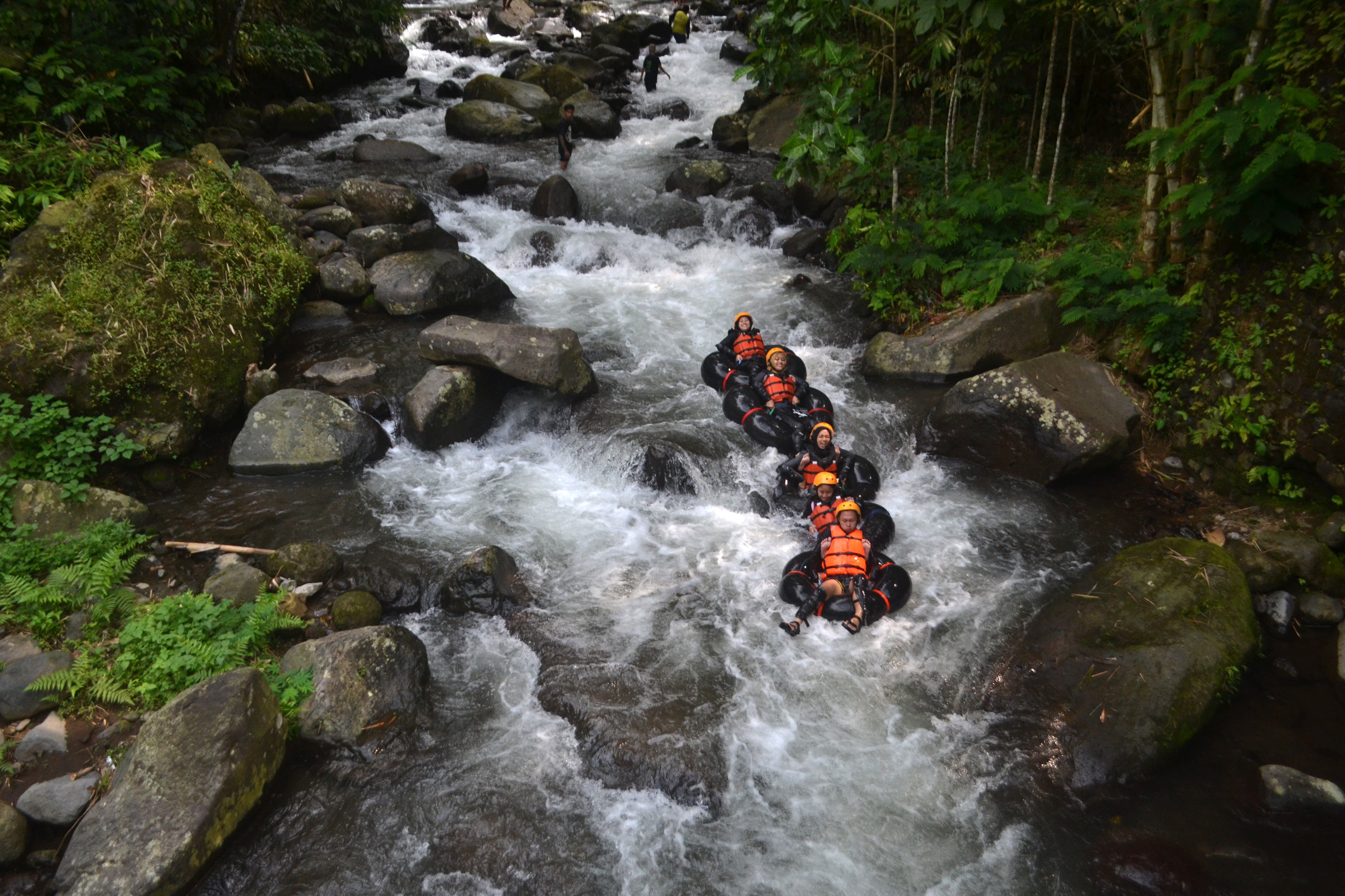 Wisatawan  melakukan tubing atau menyusuri sungai dengan ban di sungai Cikadongdong, Desa Payung, Rajagaluh, Kabupaten Majalengka, Barat.