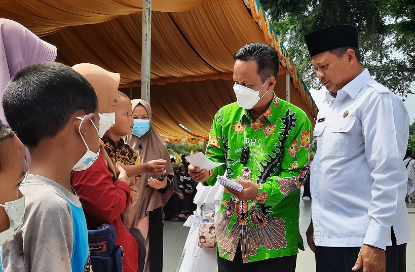 Wagub Jabar Uu Ruzhanul Ulum (kanan) memberi santunan kepada anak yatim piatu di Taman Pancaniti, Cianjur, Kamis (21/10). 