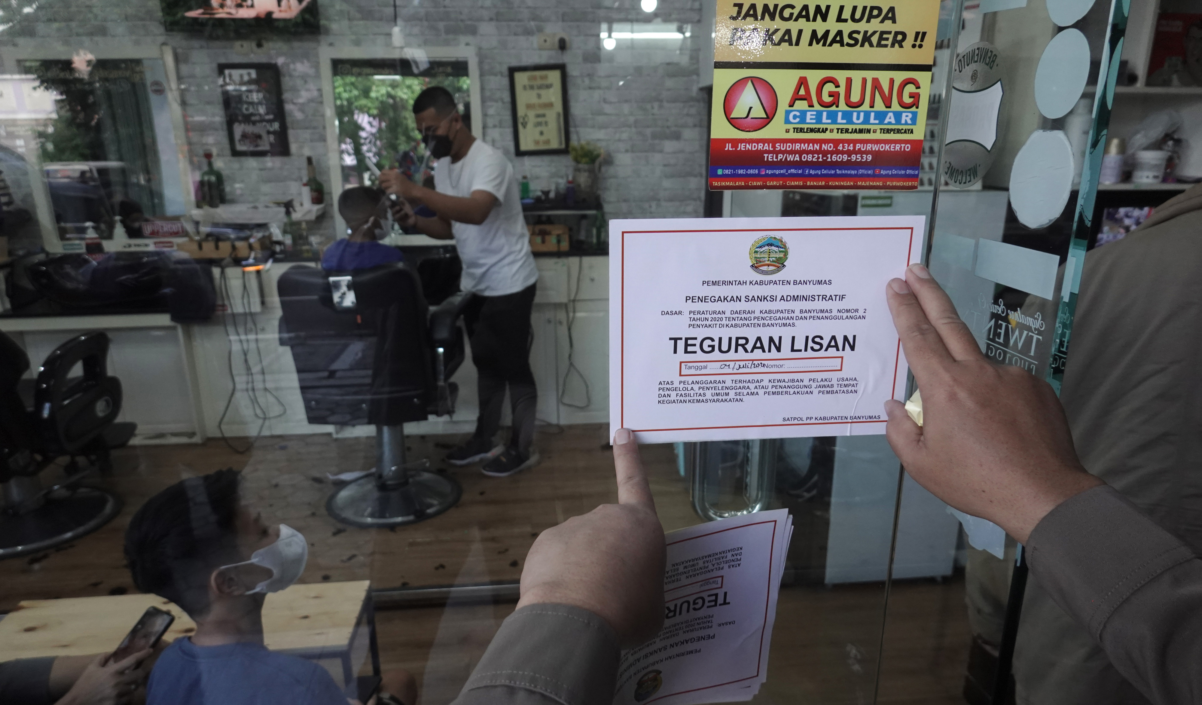  Petugas menempelkan surat teguran kepada pemilik usaha yang melanggar ketentuan PPKM darurat di Purwokerto, Banyumas, Jateng, Minggu (4/7/2