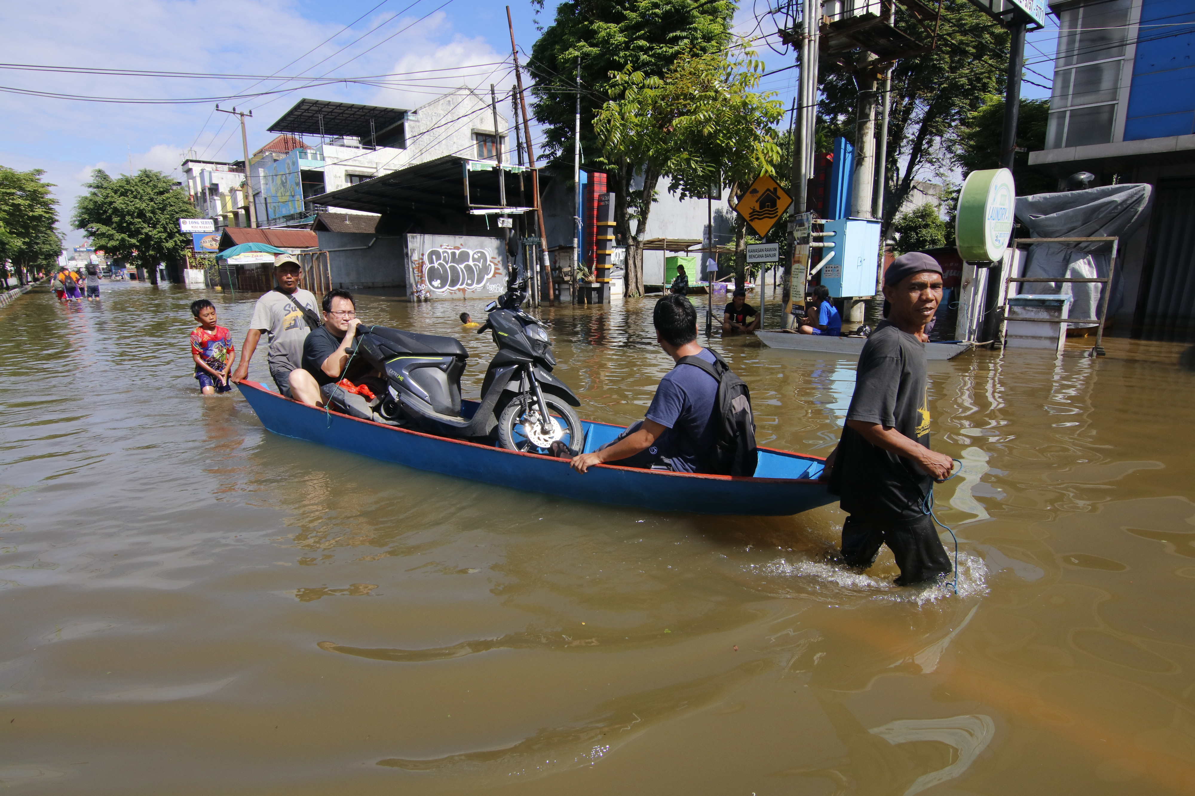 Ilustrasi pekerja menarik perahu yang disewakan untuk mengangkut warga korban banjir di wilayah Samarinda.
