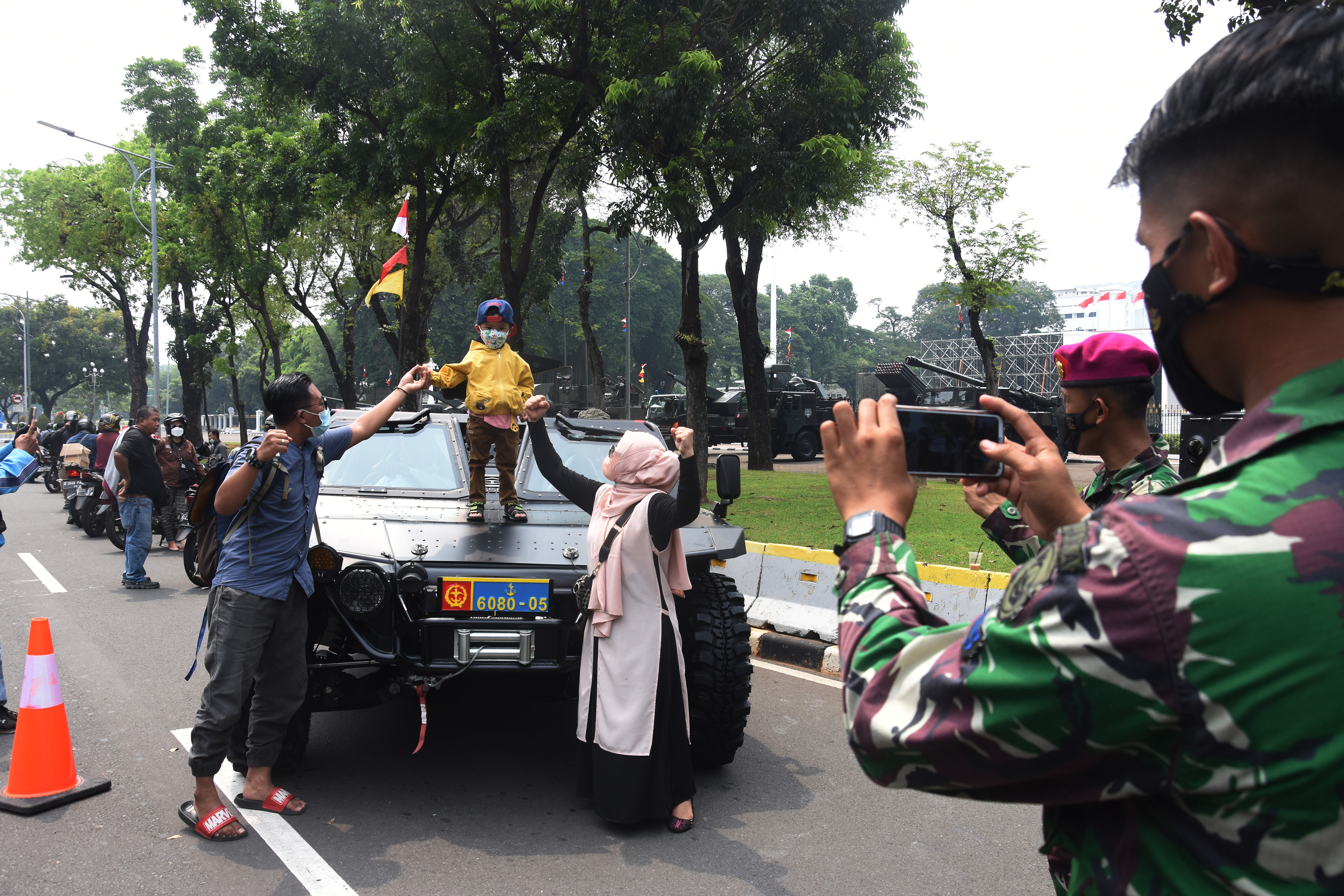 Prajurit TNI memfoto warga yang menaiki kendaraan tempur milik TNI di depan Istana Merdeka Jakarta, hari ini.