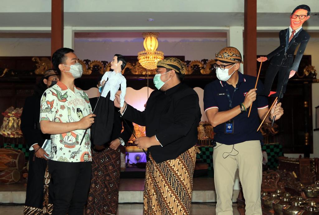 Menparekraf Sandiaga Uno (kanan) dan Wali Kota Solo Gibran Raka Bumi (kiri) saat menyaksikan pementasan wayang kulit di Solo, Jateng.