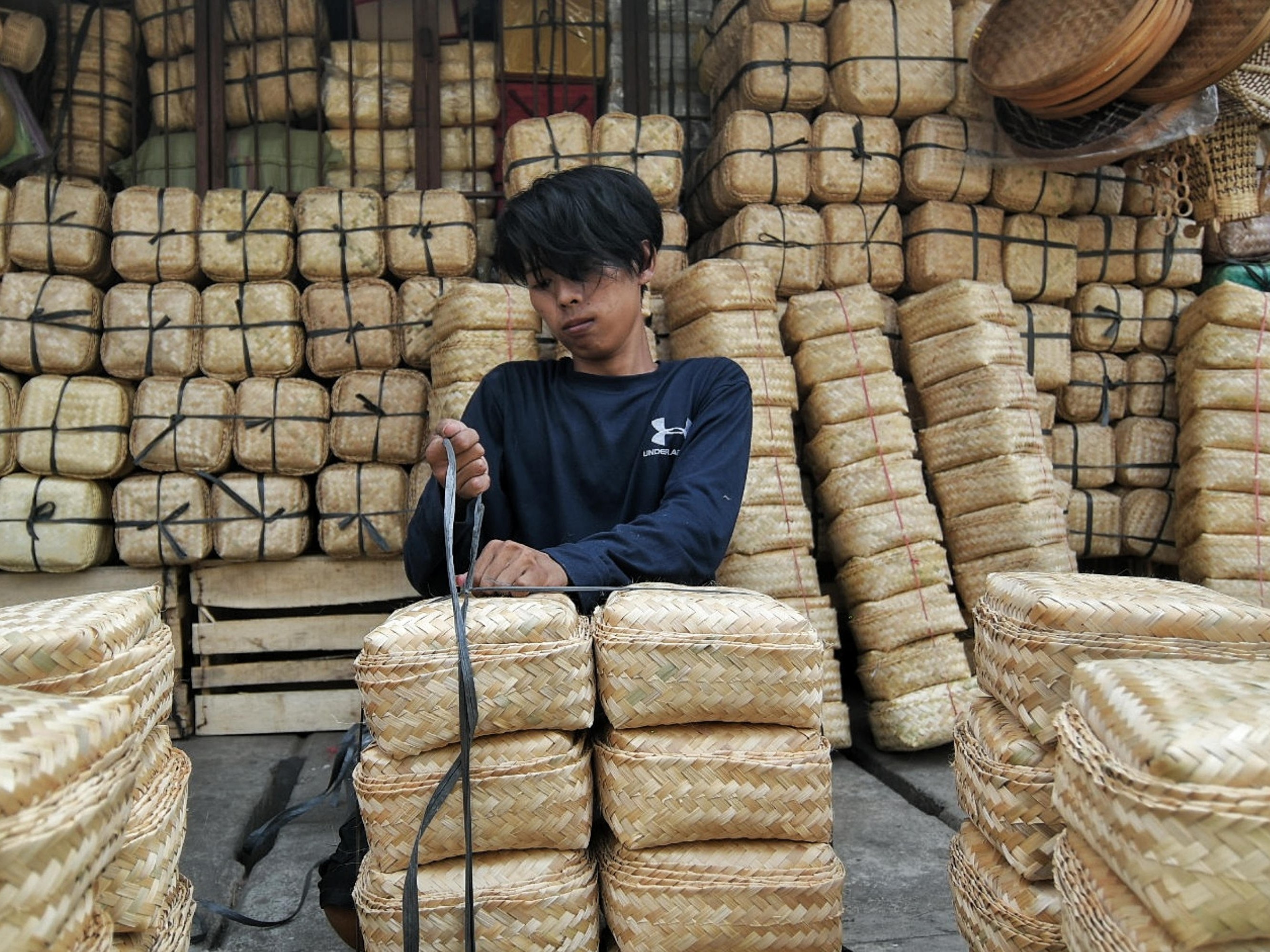 Pekerja menata kerajinan besek bambu di kawasan Jatinegara, Jakarta.