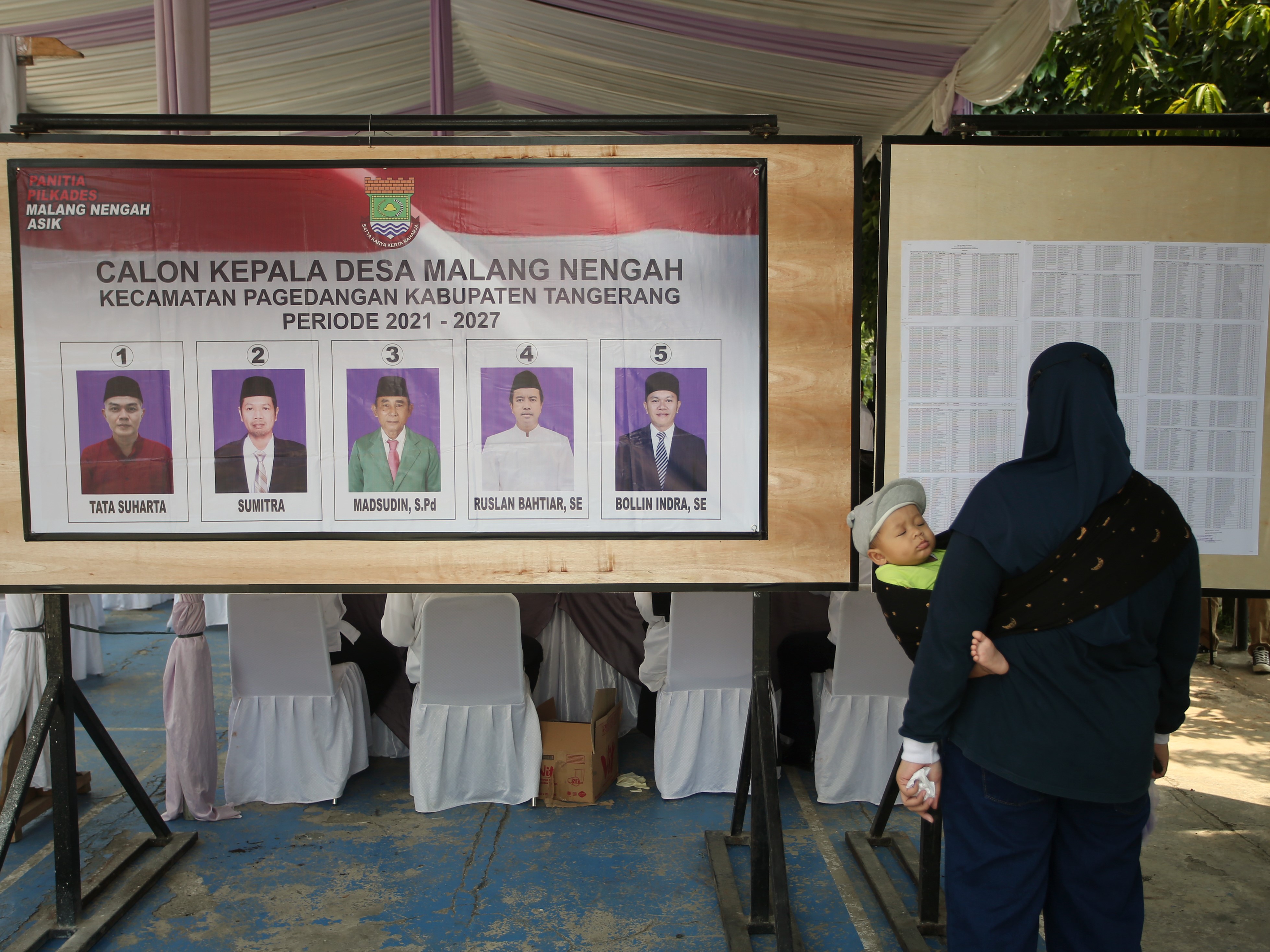 Warga calon pemilih melihat DPT saat Pilkades Serentak Kabupaten Tangerang di Pagedangan, Minggu (10/10).