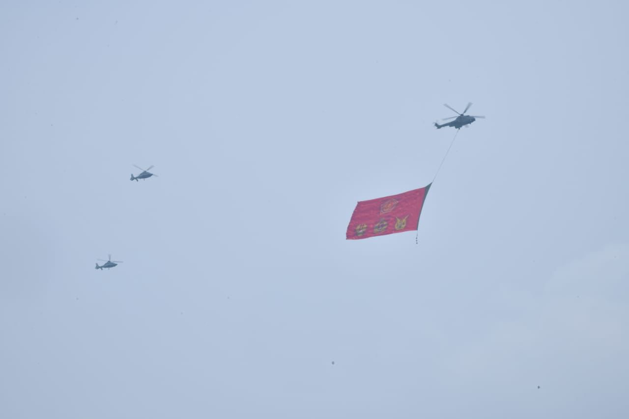 Sejumlah helikopter membawa bendera ,ambamg TNI melintas di Istana Negara. 