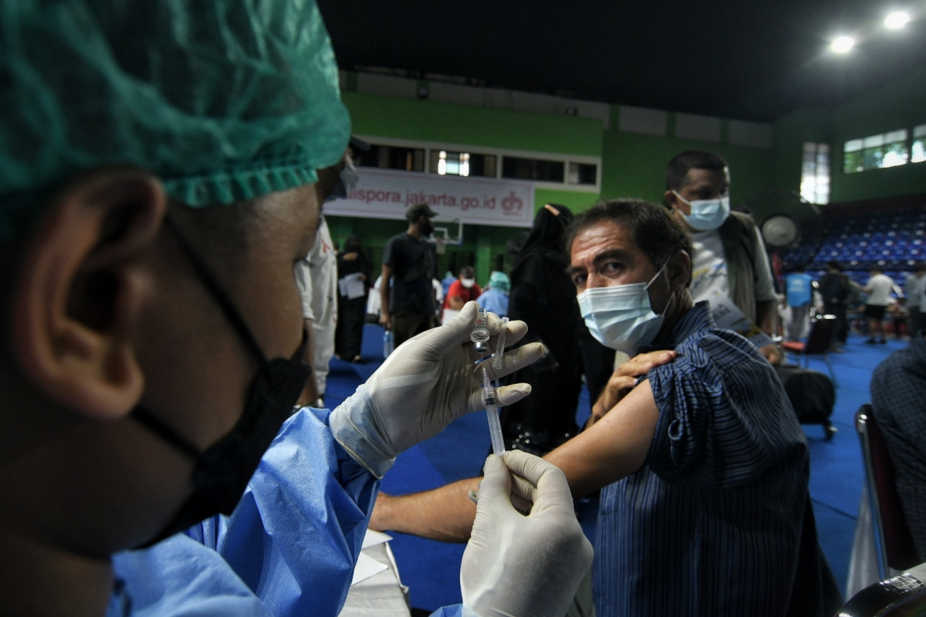 Warga saat bersiap divaksin covid-19 oleh petugas medis di Jakarta.
