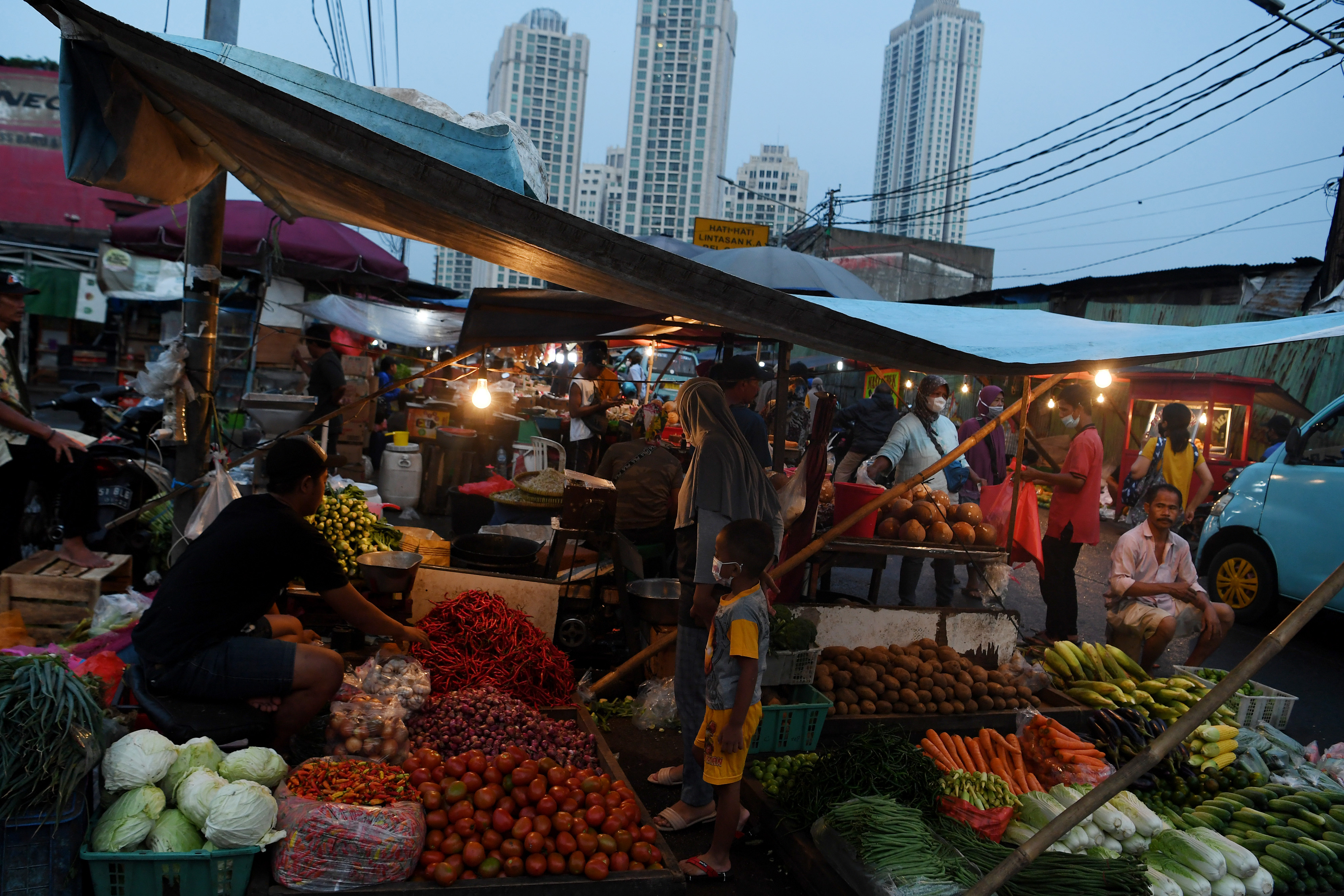 Pedagang sayur melayani pembeli di kawasan Pasar Kebayoran Lama, Jakarta.