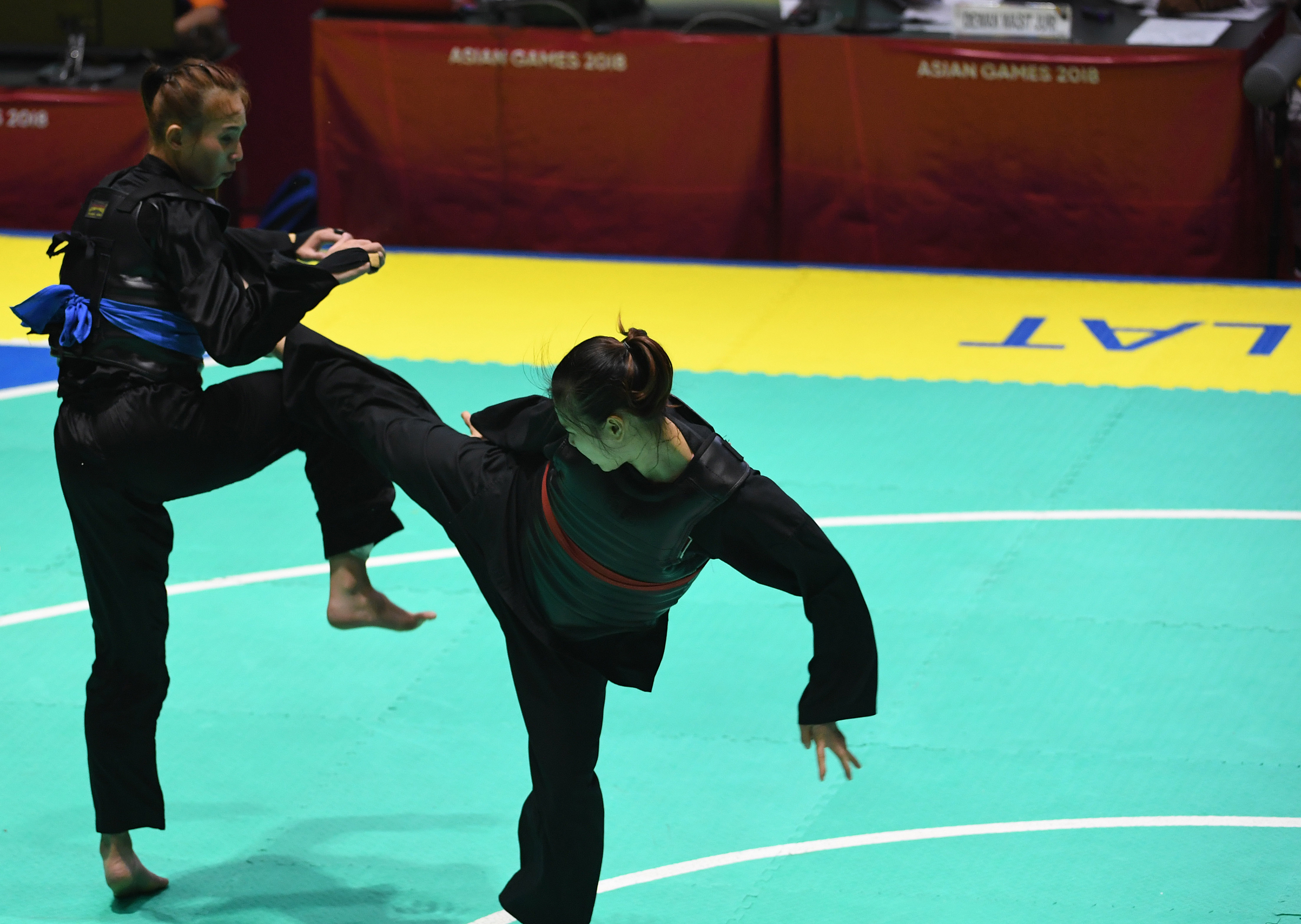 Pesilat Indonesia Wewey Wita (kiri) melakukan tendangan ke arah pesilat Vietnam Thi Them Tran (kanan) dalam Kelas B Putri Asian Games 2018. 