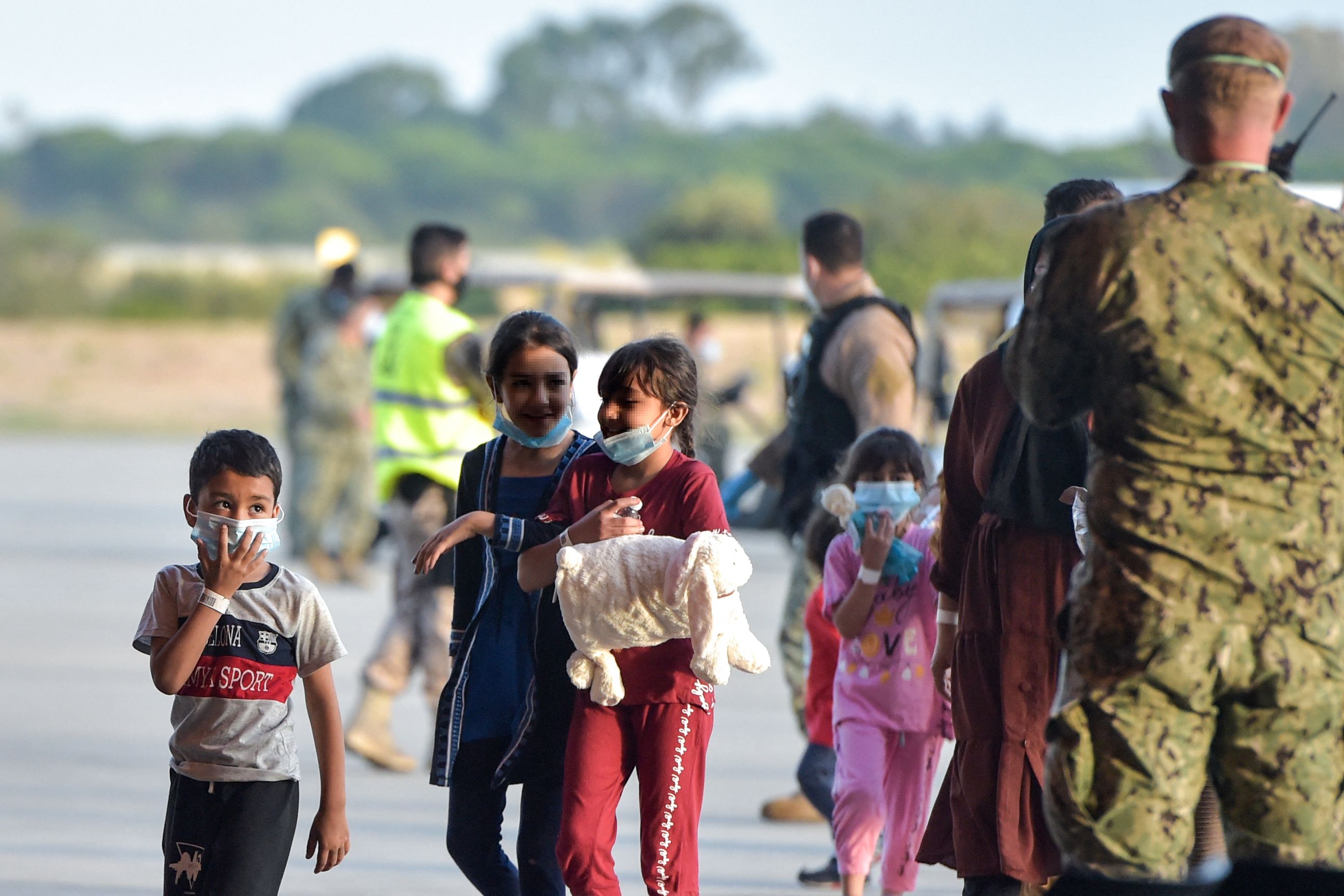 Anak-anak Afghanistan turun dari pesawat di pangkalan militer Rota, Spanyol.