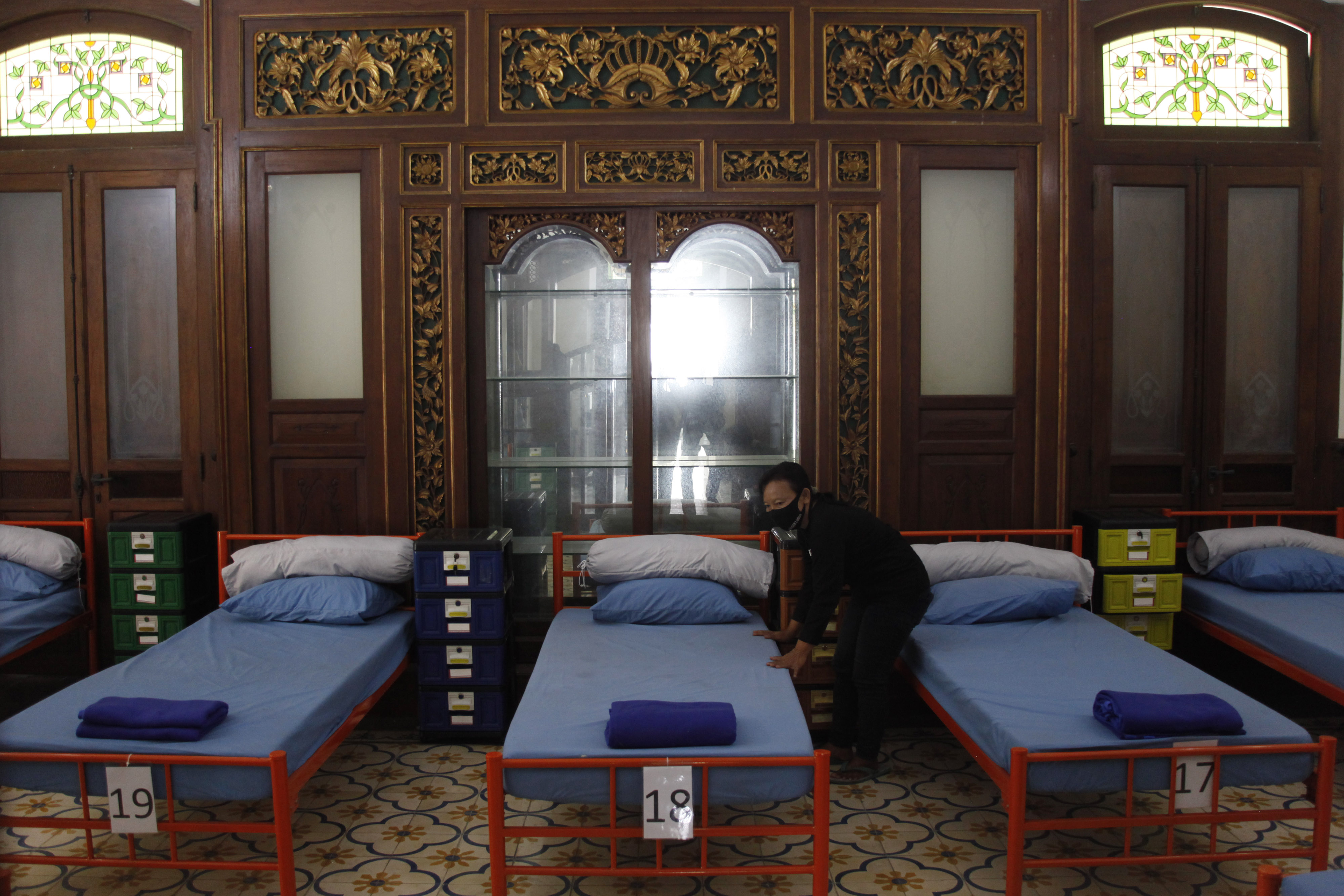  Petugas membawa tempat tidur untuk persiapan lokasi isolasi terpusat bagi anak- anak di Ndalem Priyosuhartan Solo, Jawa Tengah.