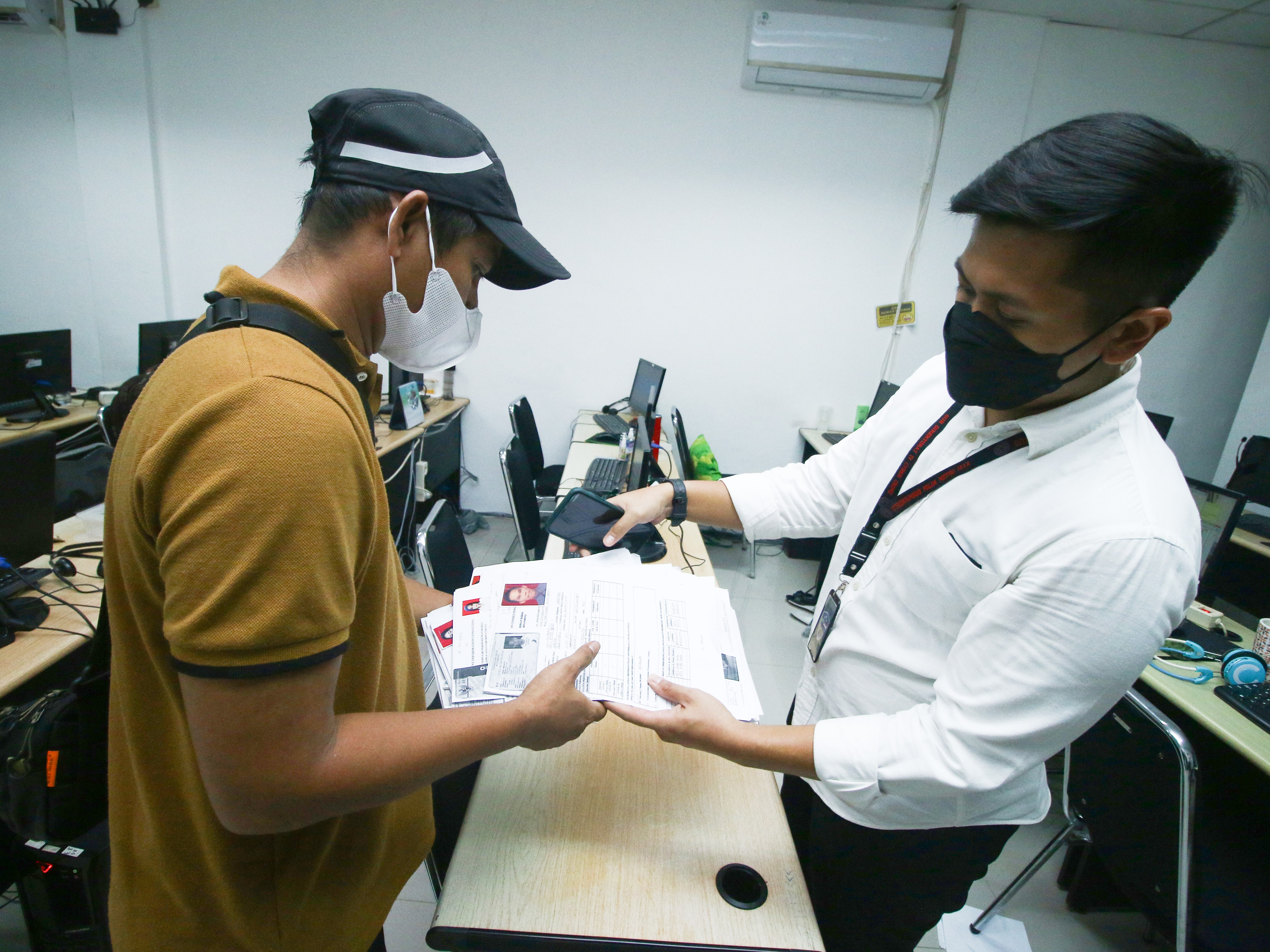 Petugas memeriksa dokumen PT Ant Information Consulting saat penggerebekan kantor pinjol ilegal di Kelapa Gading, Jakarta, Senin (18/10).