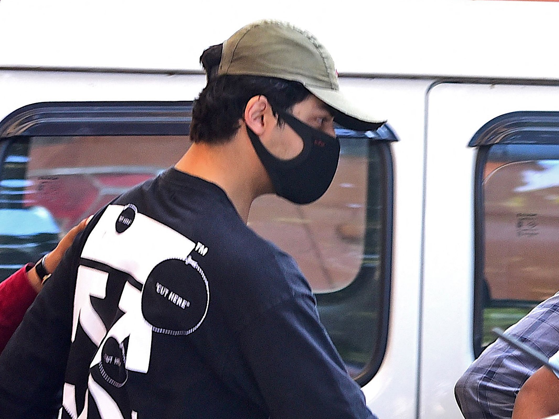 Putra aktor Bollywood Shah Rukh Khan, Aryan Khan, sedang dikawal oleh petugas penegak hukum di luar kantor Narcotics Control Bureau (NCB).