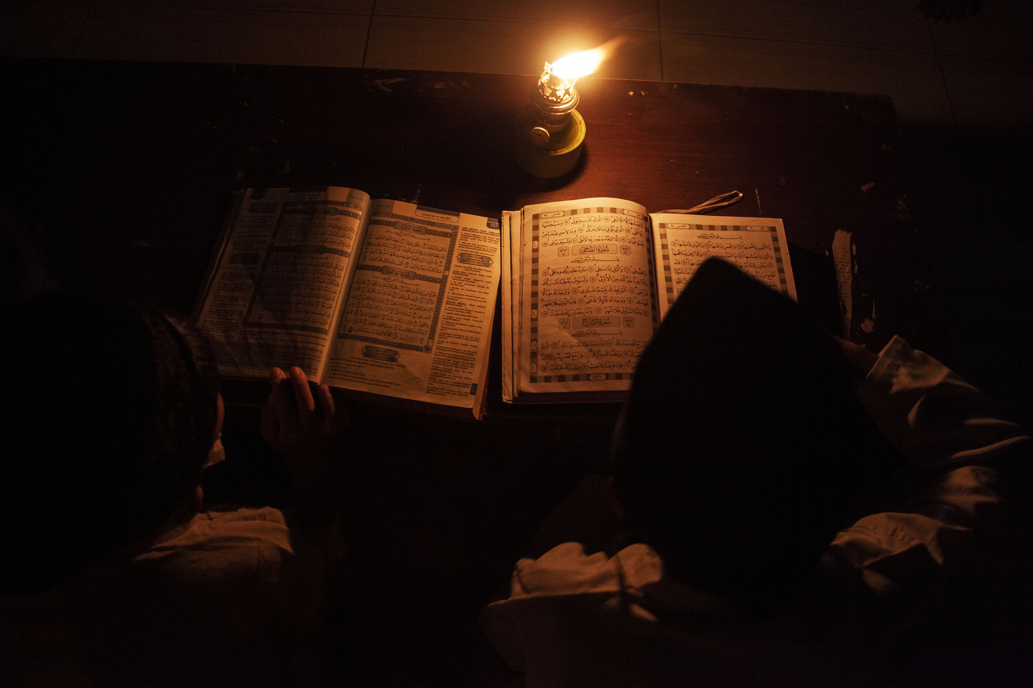  Sejumlah santri mengaji Al Quran menggunakan penerangan lilin dan lampu minyak