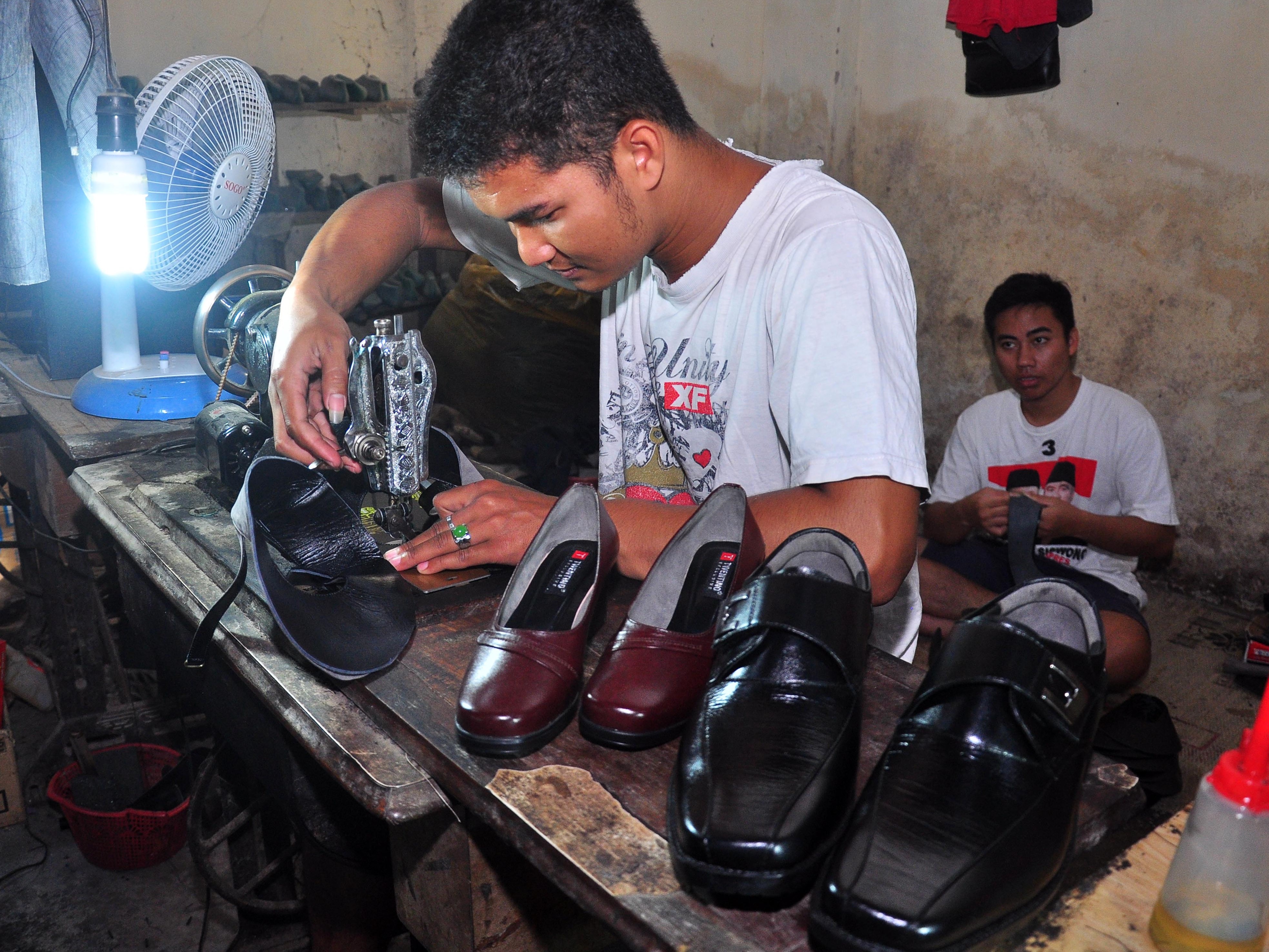 Seorang perajin menyelesaikan proses pembuatan sepatu di Babadan, Karanganom, Klaten, Jawa Tengah.