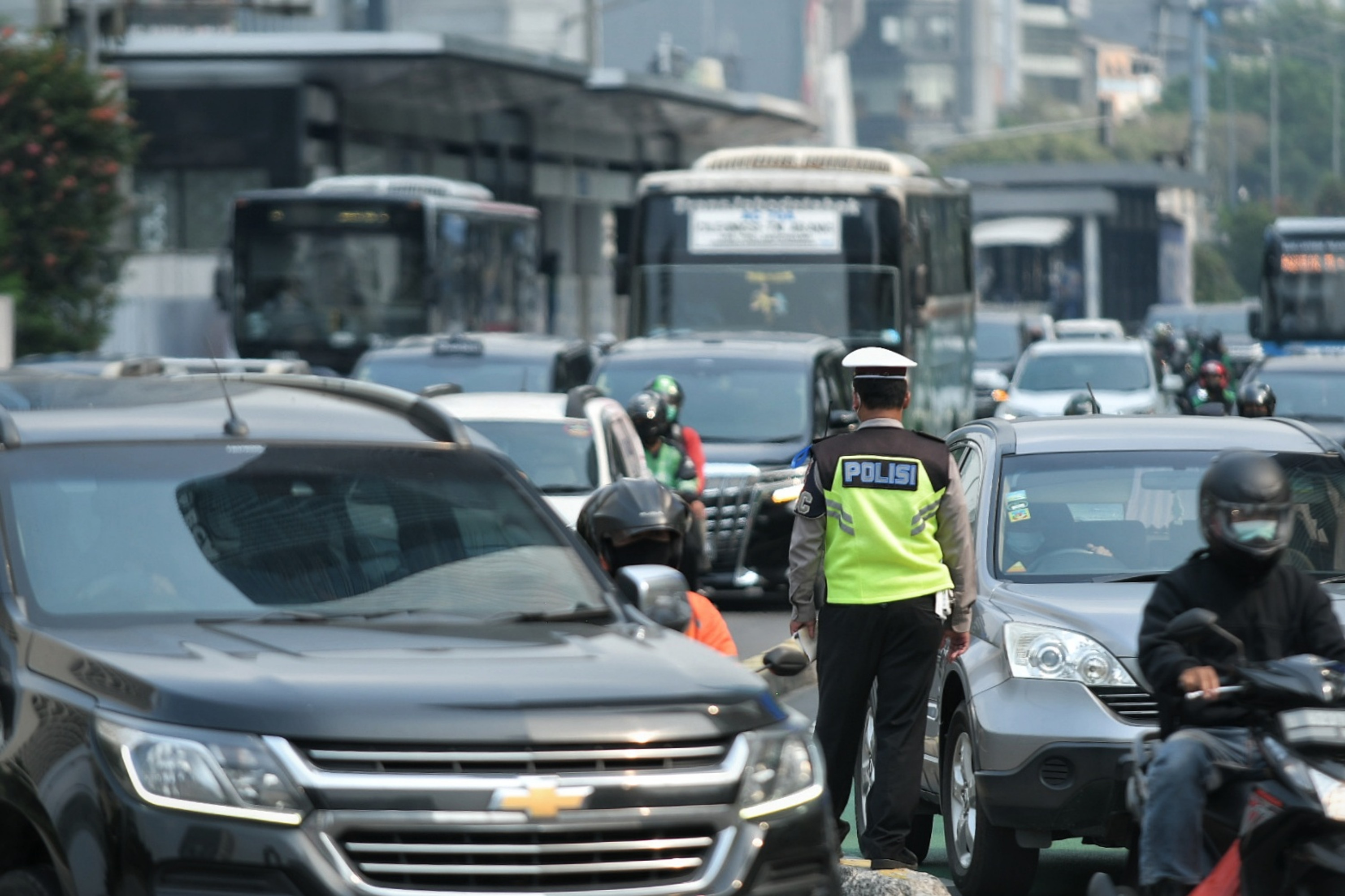 Petugas kepolisian saat memantau pergerakan lalu lintas kendaraan di wilayah Jakarta.
