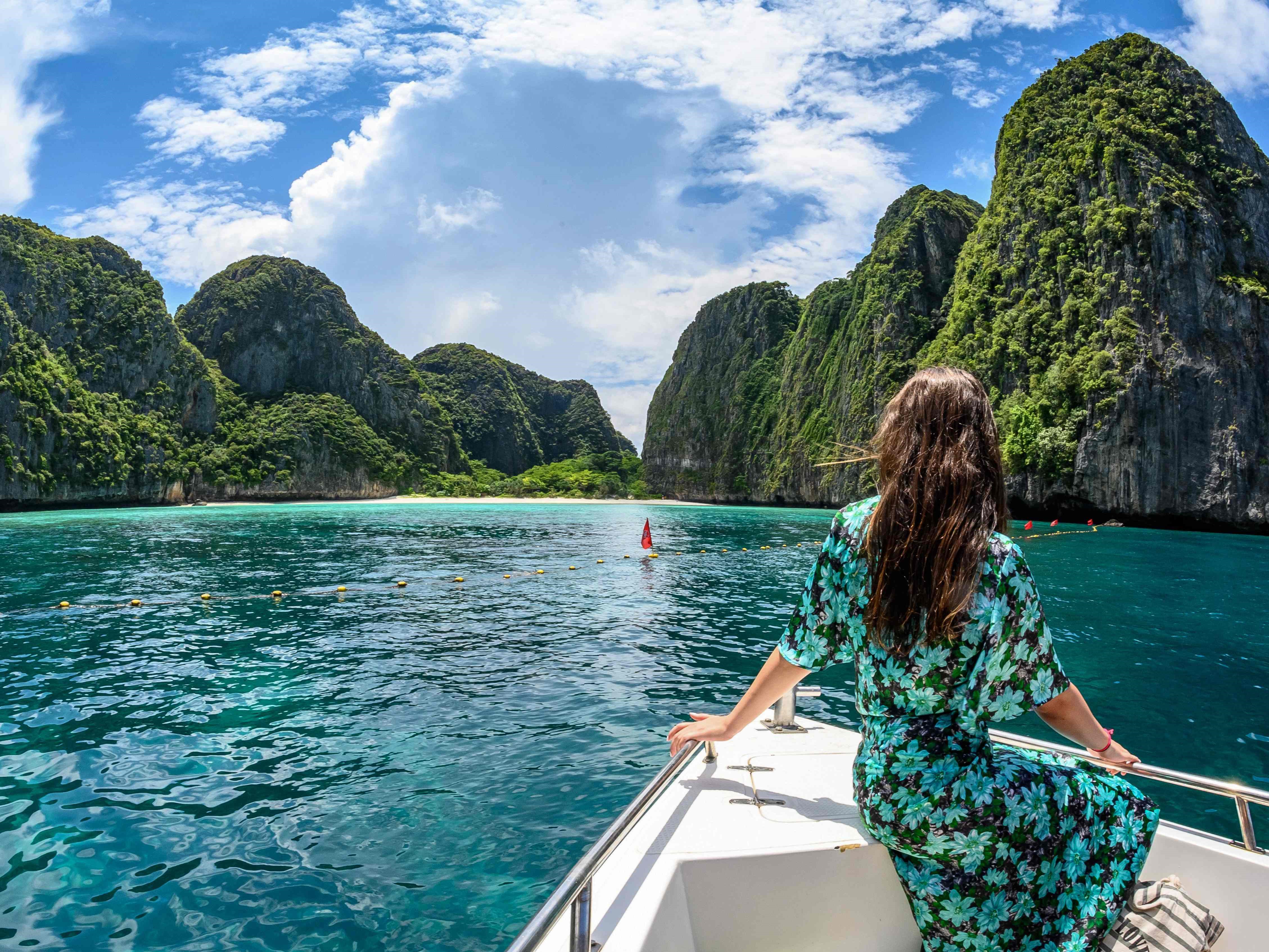 Seorang turis berpose di atas perahu di Teluk Maya bagi pengunjung di pulau Thailand selatan, Koh Phi Phi.