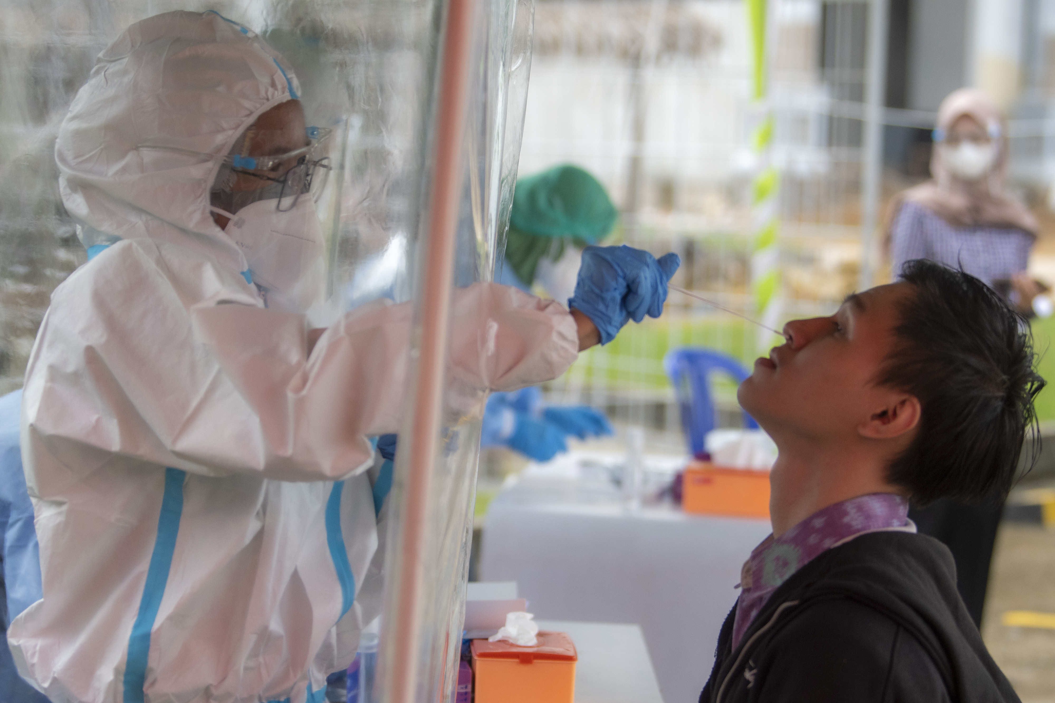 Ilustrasi petugas medis melakukan tes usap PCR kepada seorang warga.