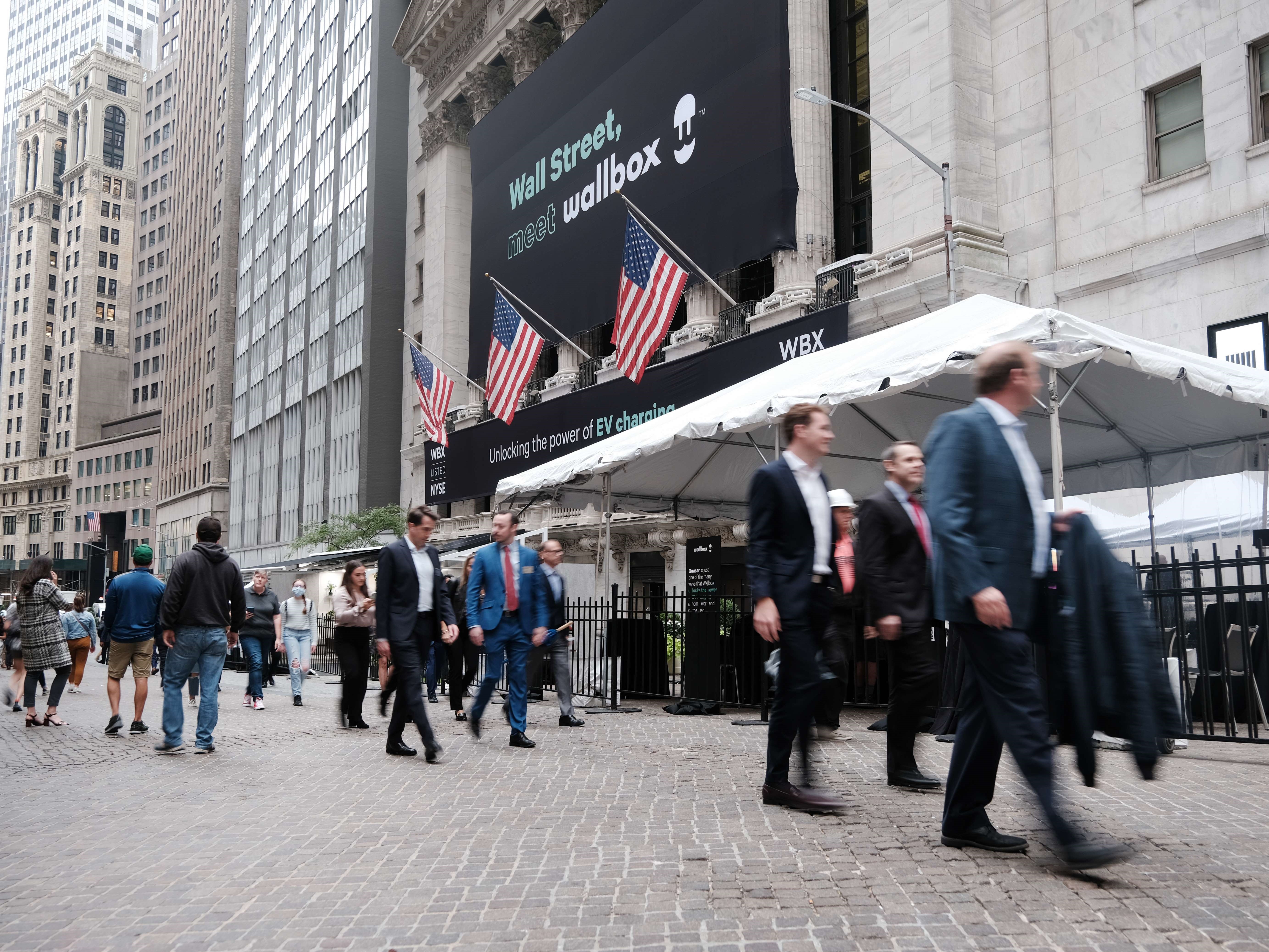 Orang-orang berjalan di luar New York Stock Exchange, Senin (4/10).