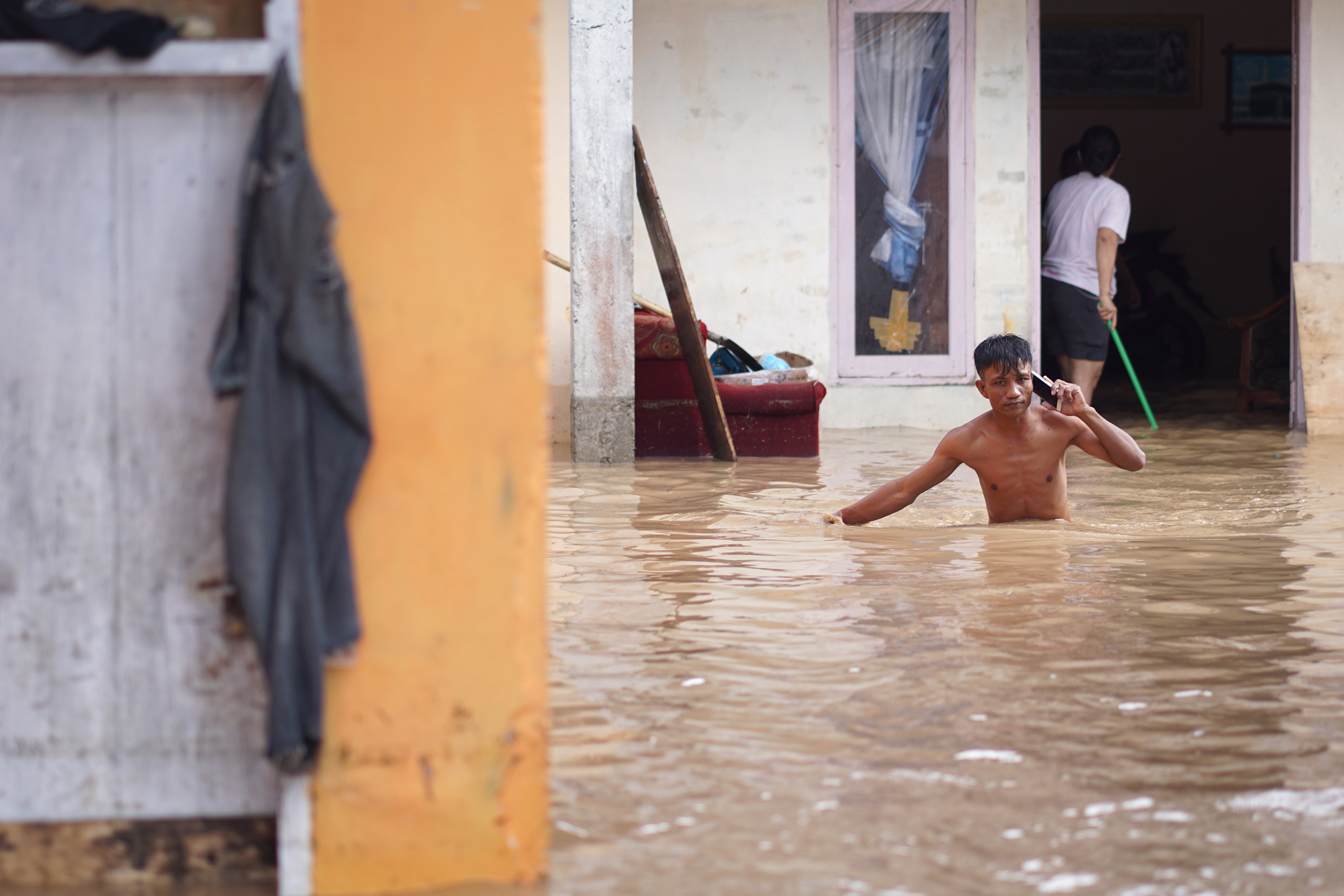 Warga berjalan melintasi banjir di wilayah Limboto, Kabupaten Gorontalo.