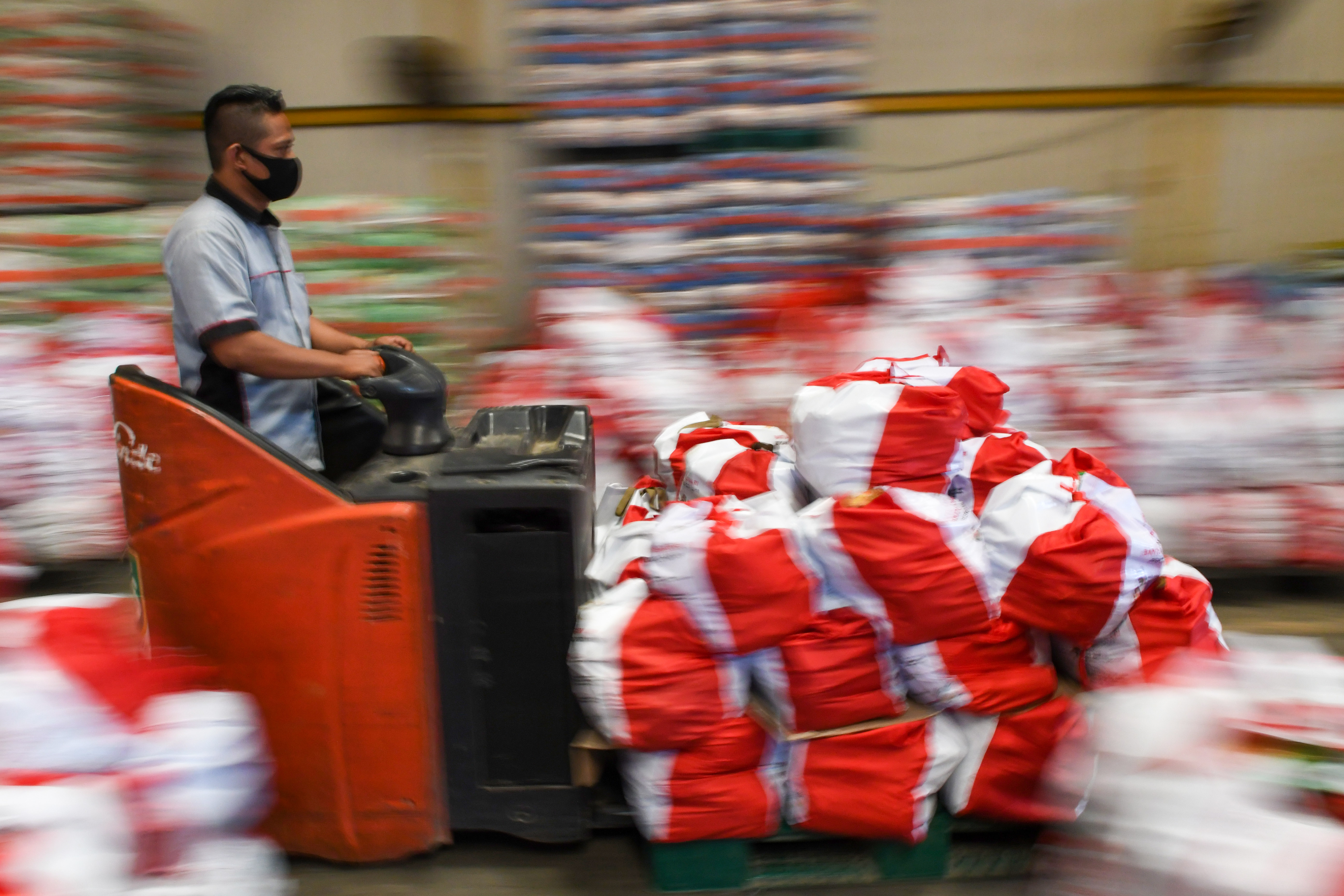 Ilustrasi pekerja memindahkan paket bansos covid-19 yang akan disalurkan ke masyarakat.