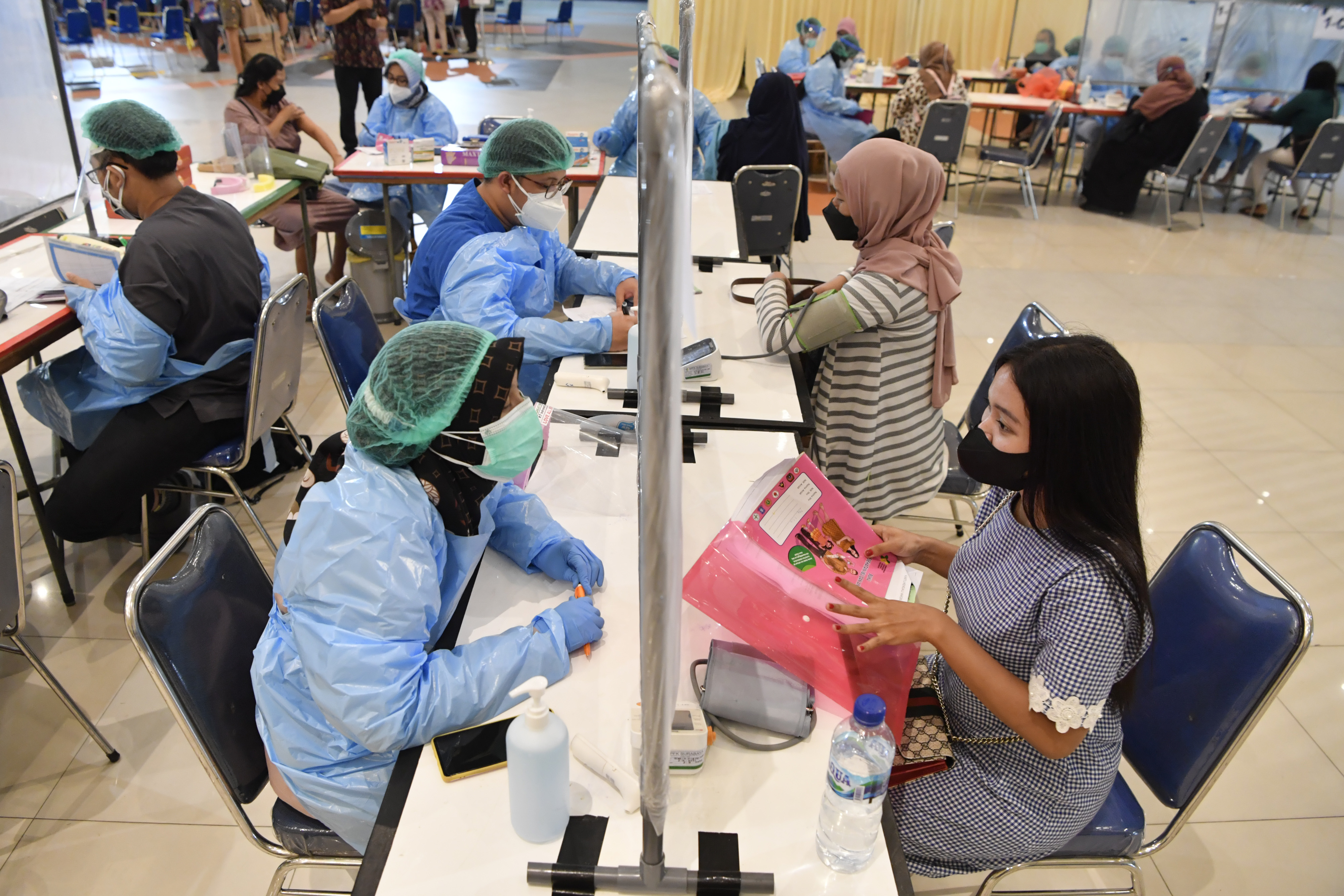 Petugas kesehatan memeriksa kondisi ibu hamil sebelum menerima vaksin Covid-19 di Surabaya, Jawa Timur, Kamis (16/9).