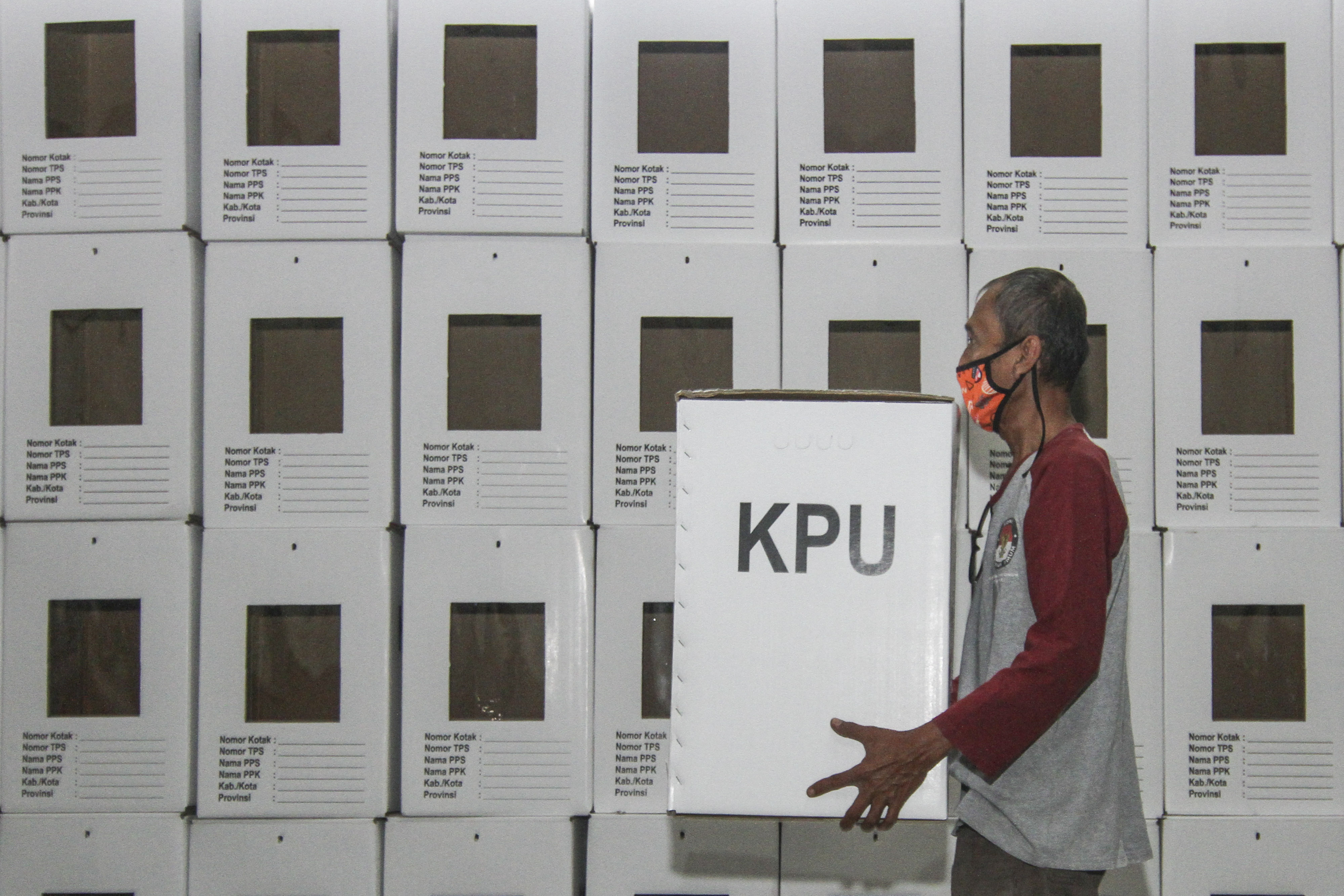 Petugas membawa kotak suara yang telah dirakit di gudang logistik KPU wilayah Depok, Jawa Barat.