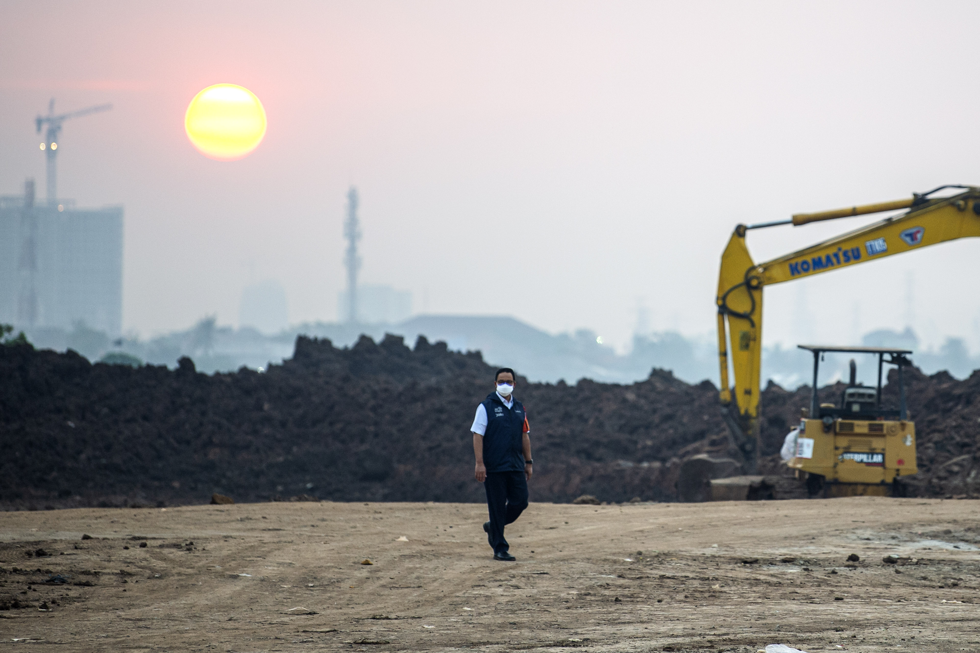 Gubernur DKI Anies Baswedan berjalan di area pemakaman khusus covid-19 di TPU Rorotan, Cilincing, Jakarta.