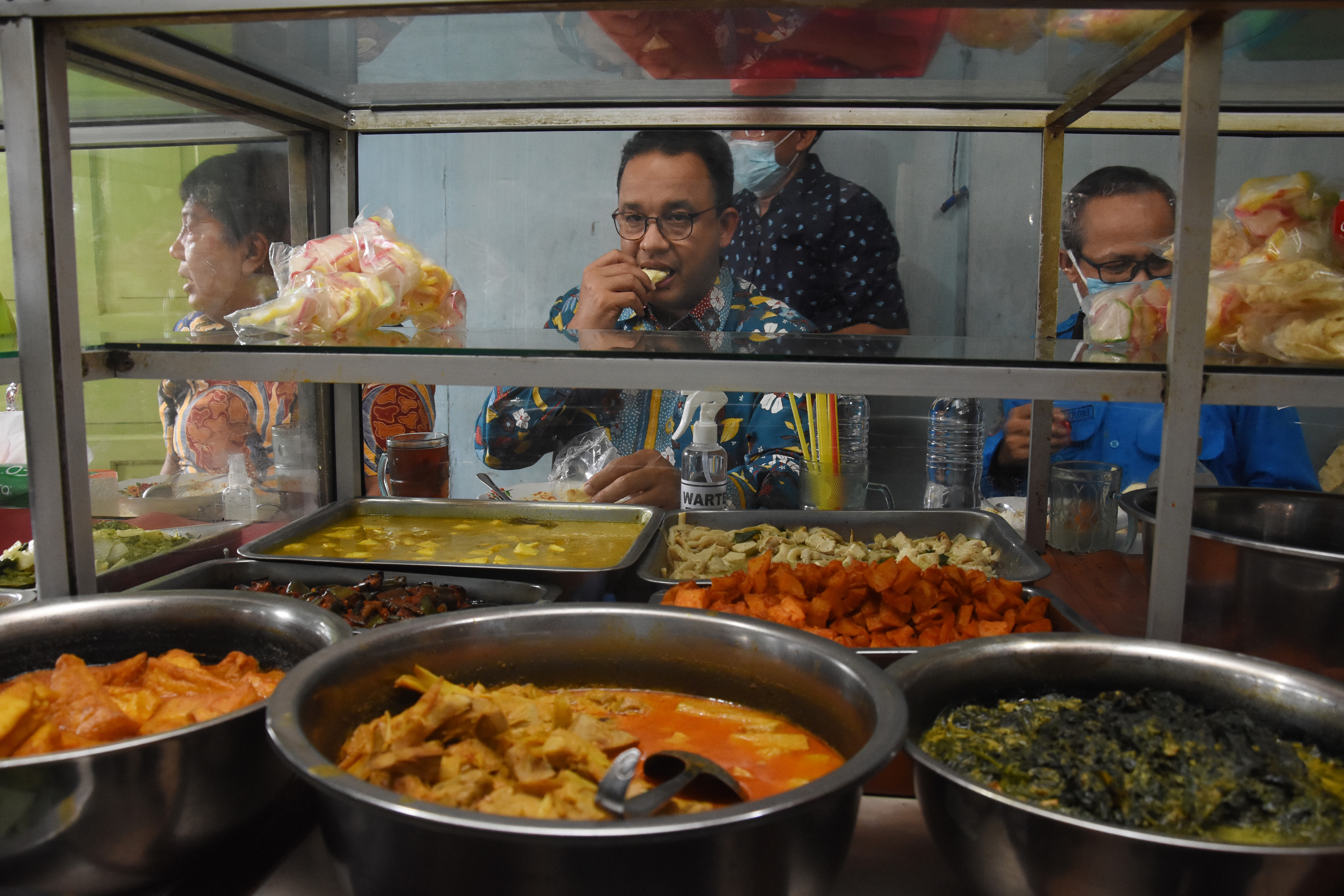 Gubernur DKI Jakarta Anies Baswedan saat makan siang di salah satu warteg.