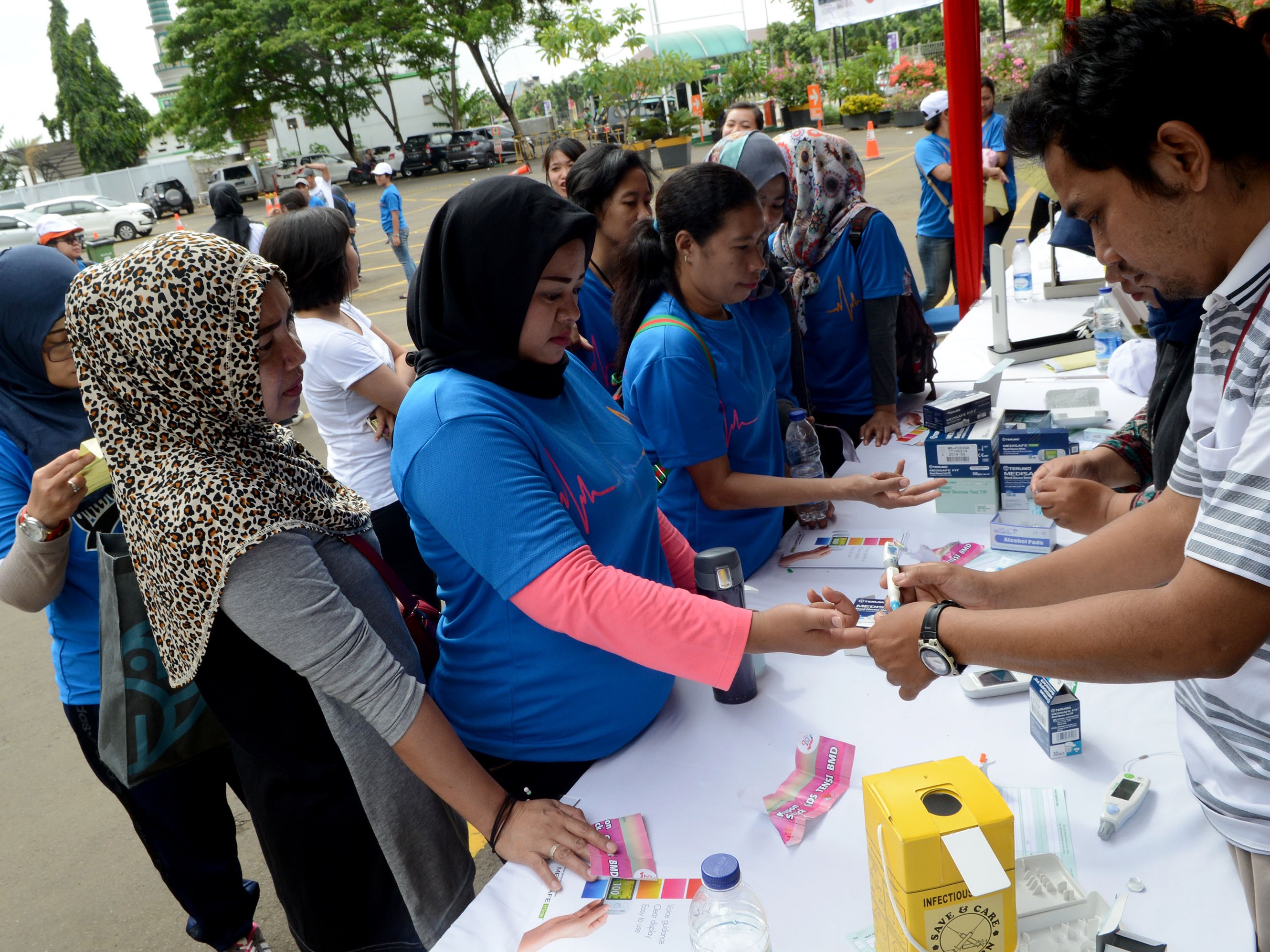 Warga sedang melakukan cek gula darah gratis.