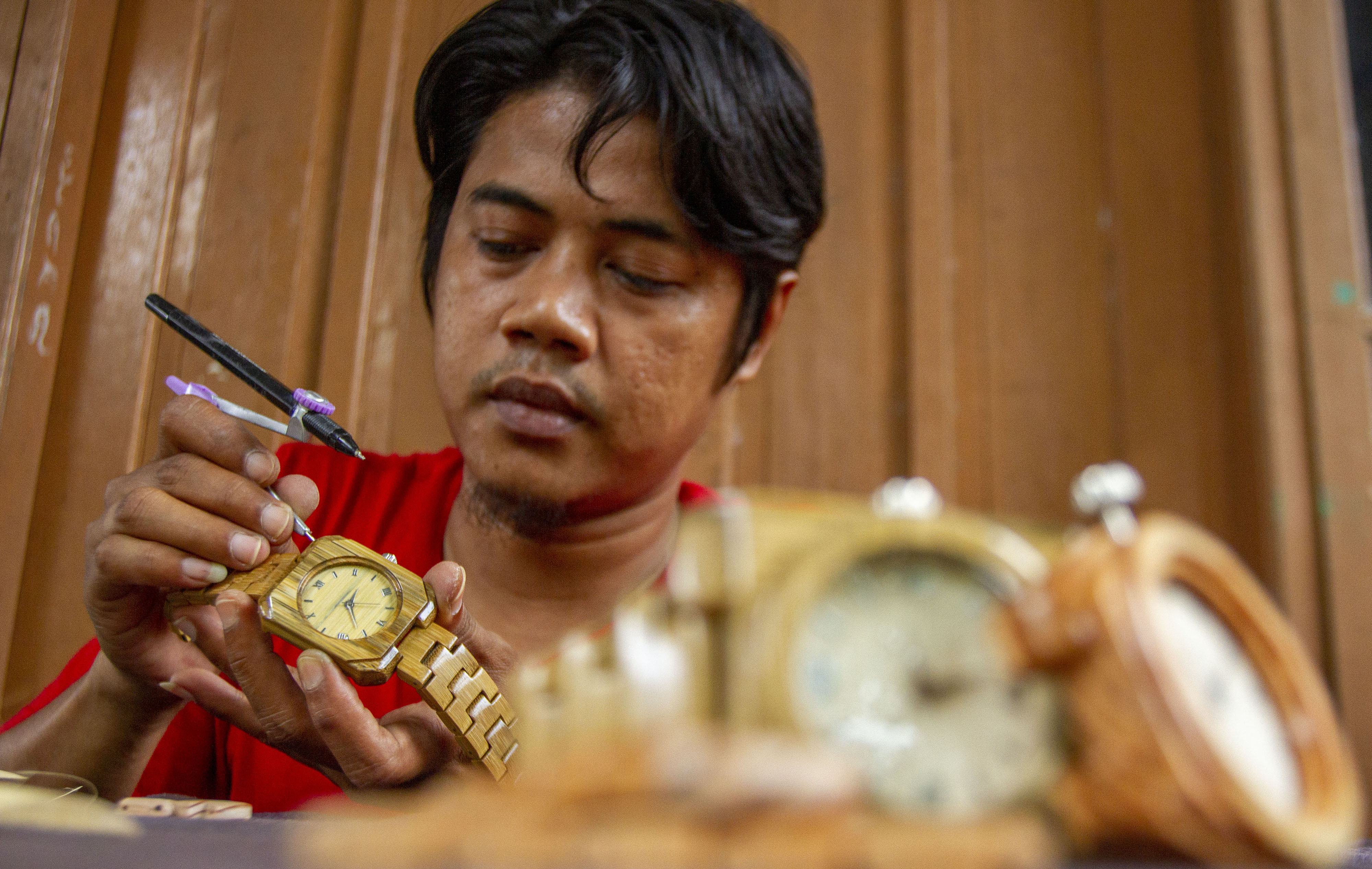 Perajin menyelesaikan pembuatan kerajinan jam tangan berbahan bambu di workshop BamCraft, Desa Bantarsari, Kabupaten Bekasi, Jawa Barat.