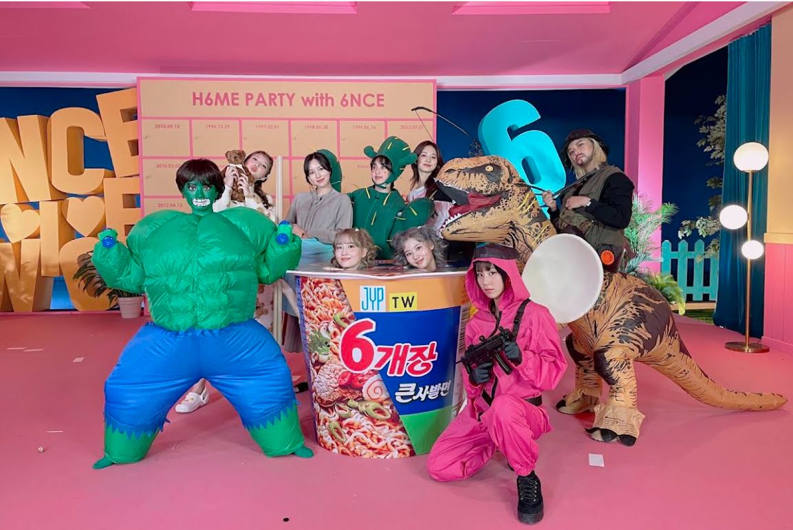 Para personel Twice mengenakan kostum.