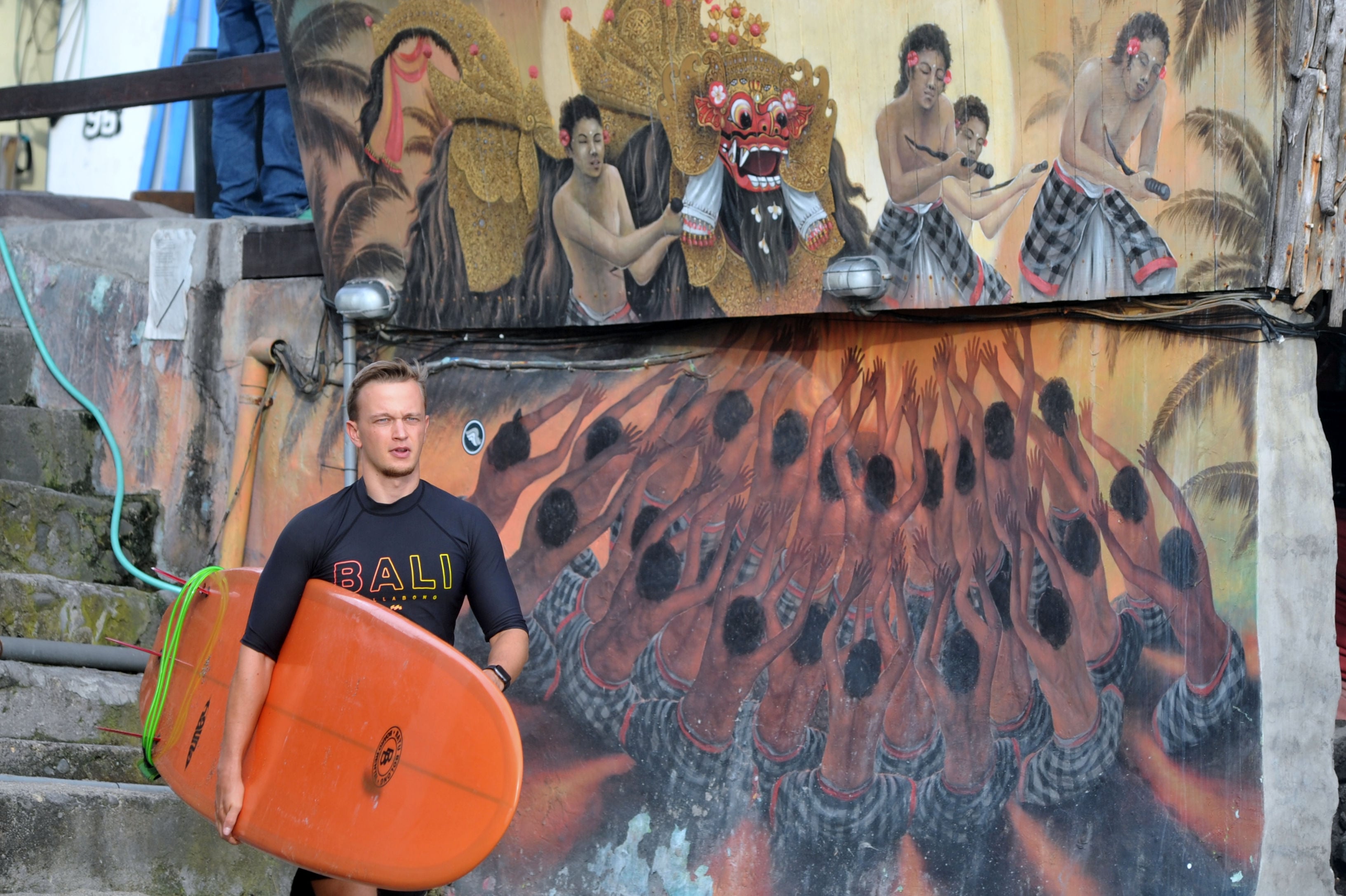 Dengan membawa papan selancar, turis asing mengunjungi kawasan Pantai Batu Bolong di Bali.