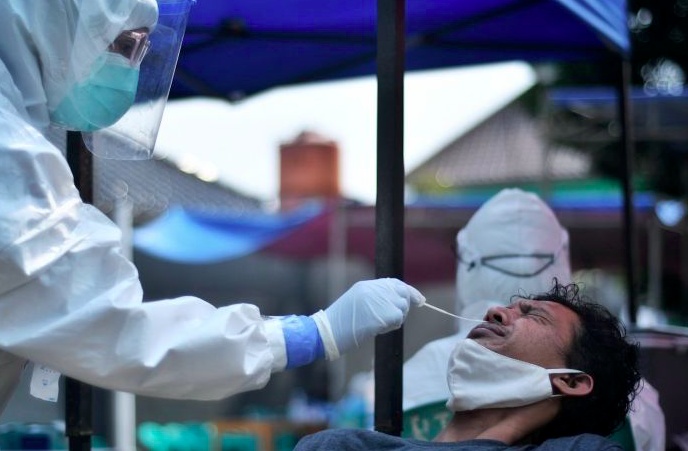 Ilustrasi - Petugas medis melakukan tes PCR kepada warga.