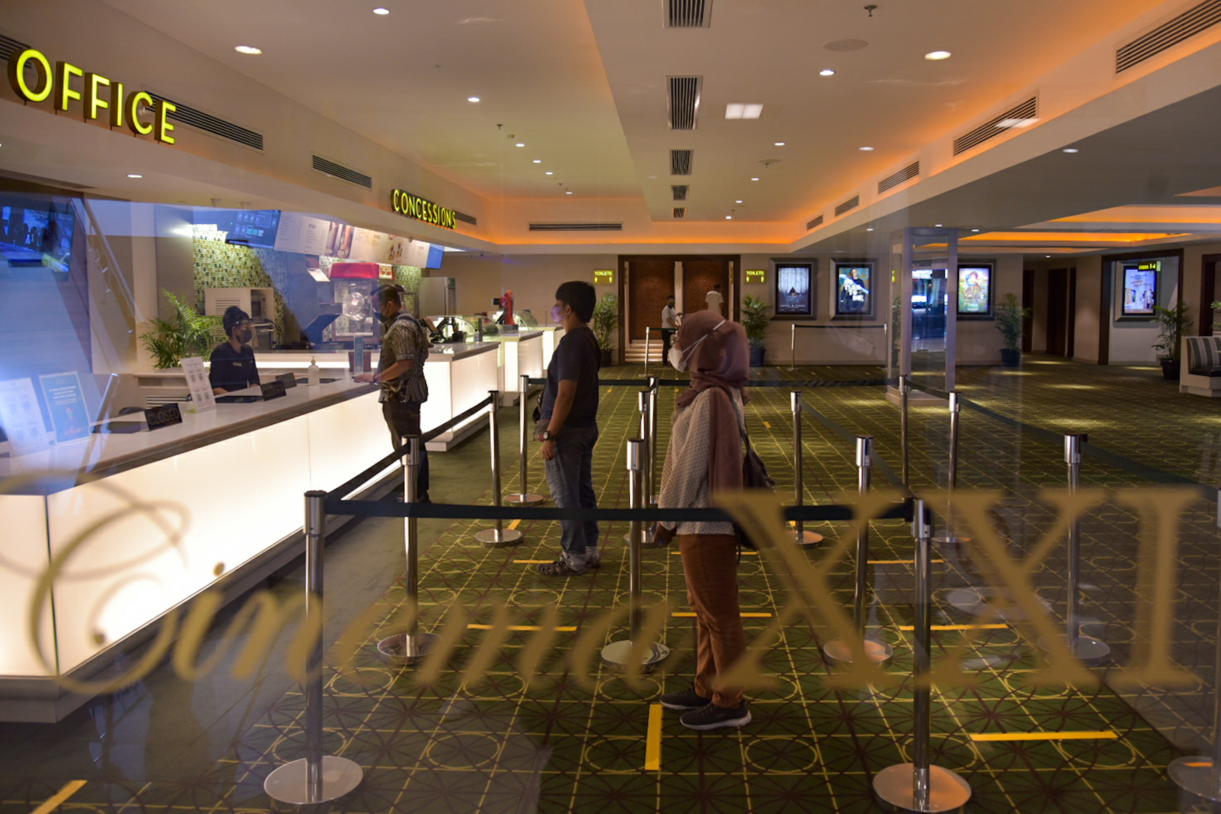 Ilustrasi warga mengantre untuk membeli tiket film di bioskop.