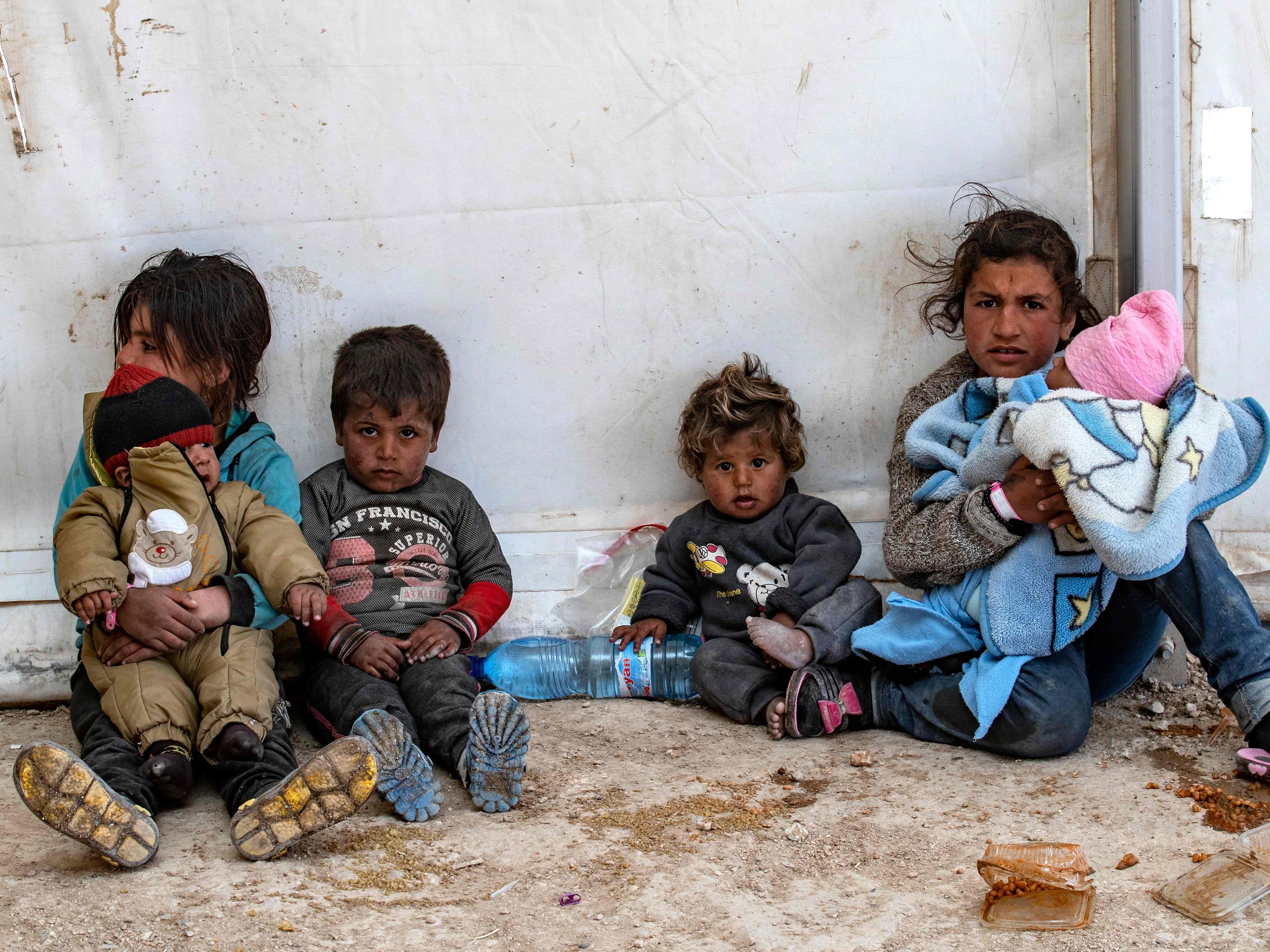 Wanita dan anak-anak Suriah duduk di kamp al-Hol yang dikelola Kurdi menampung kerabat tersangka pejuang ISIS di Hasakeh, Suriah.