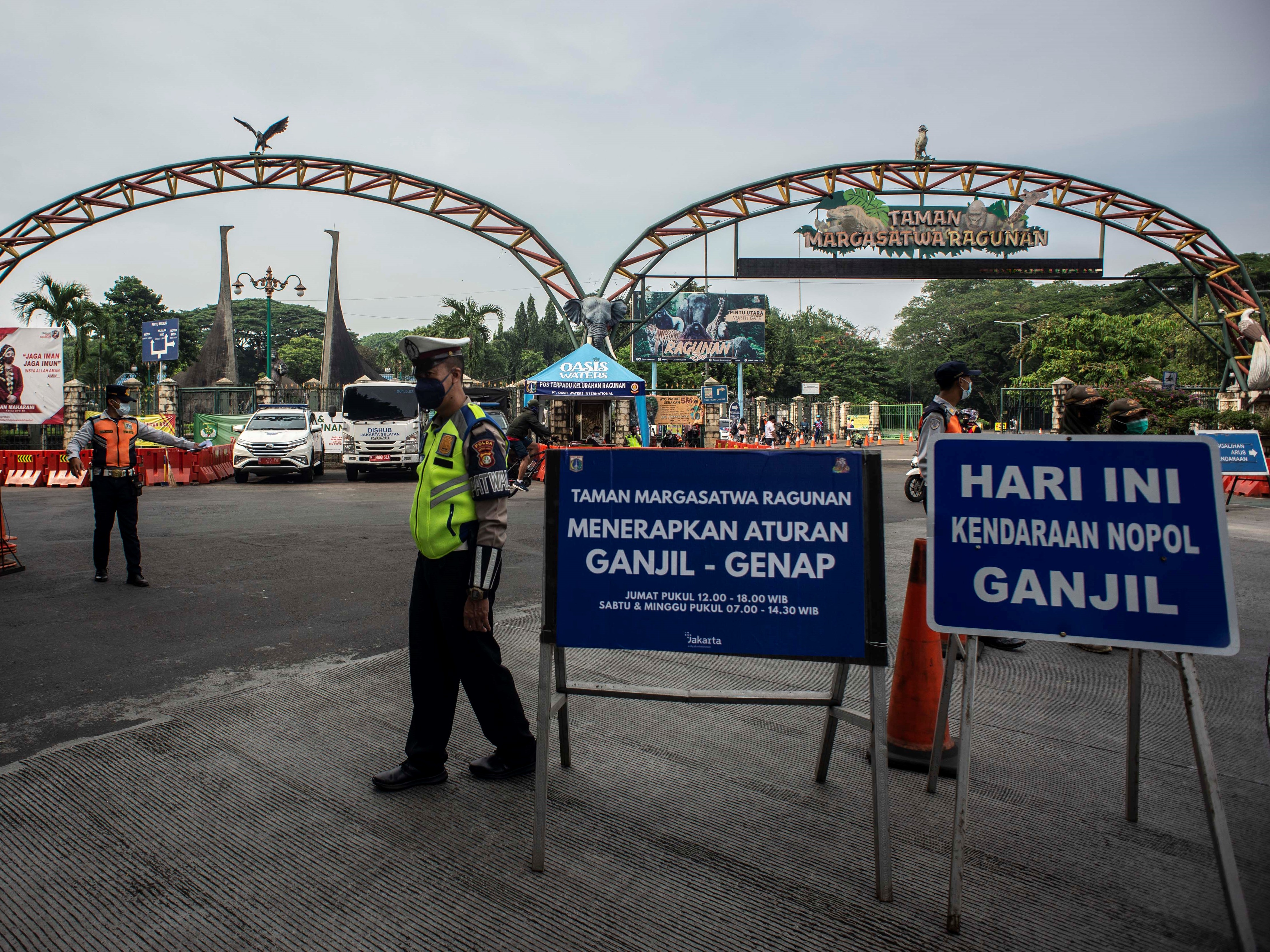 Polisi bersama petugas Dishub DKI Jakarta mengatur arus lalu lintas di depan pintu masuk Taman Margasatwa Ragunan, Jakarta, Sabtu (23/10).