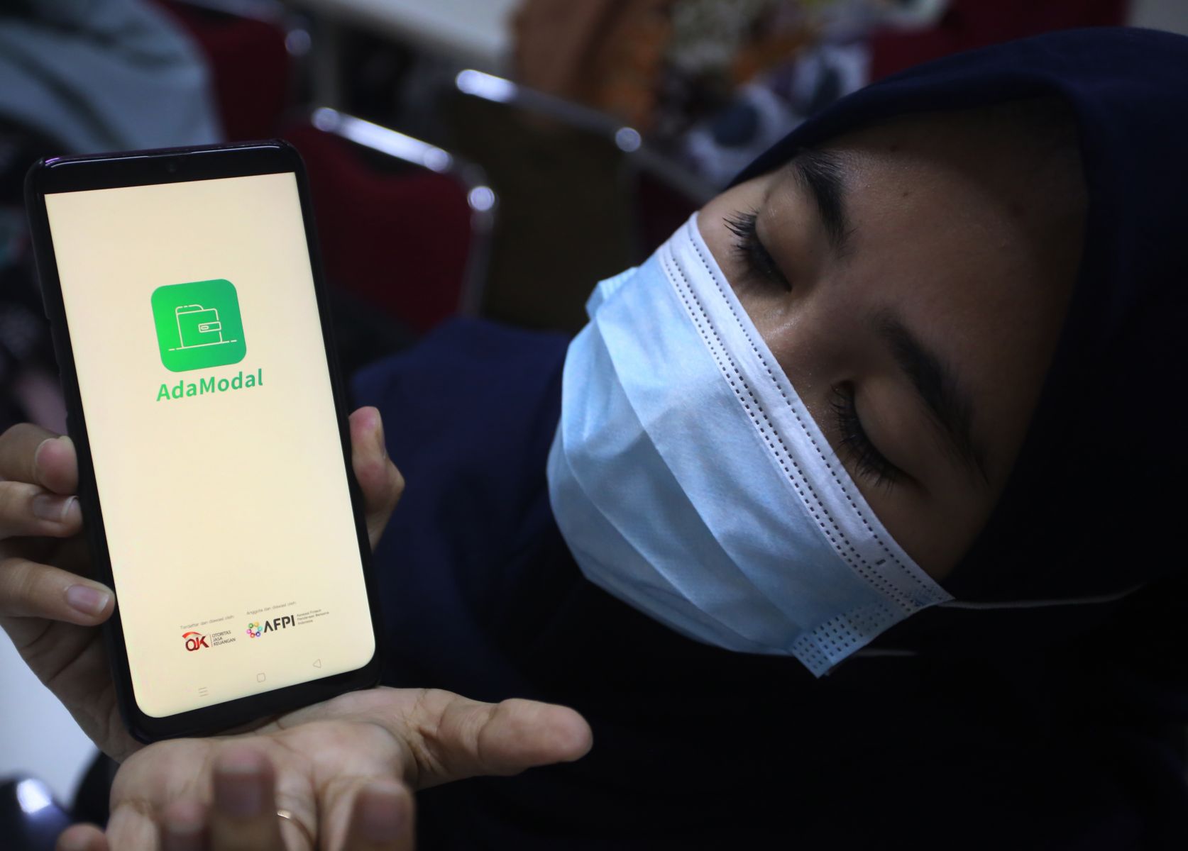 Pekerja menunjukan aplikasi pinjaman online 